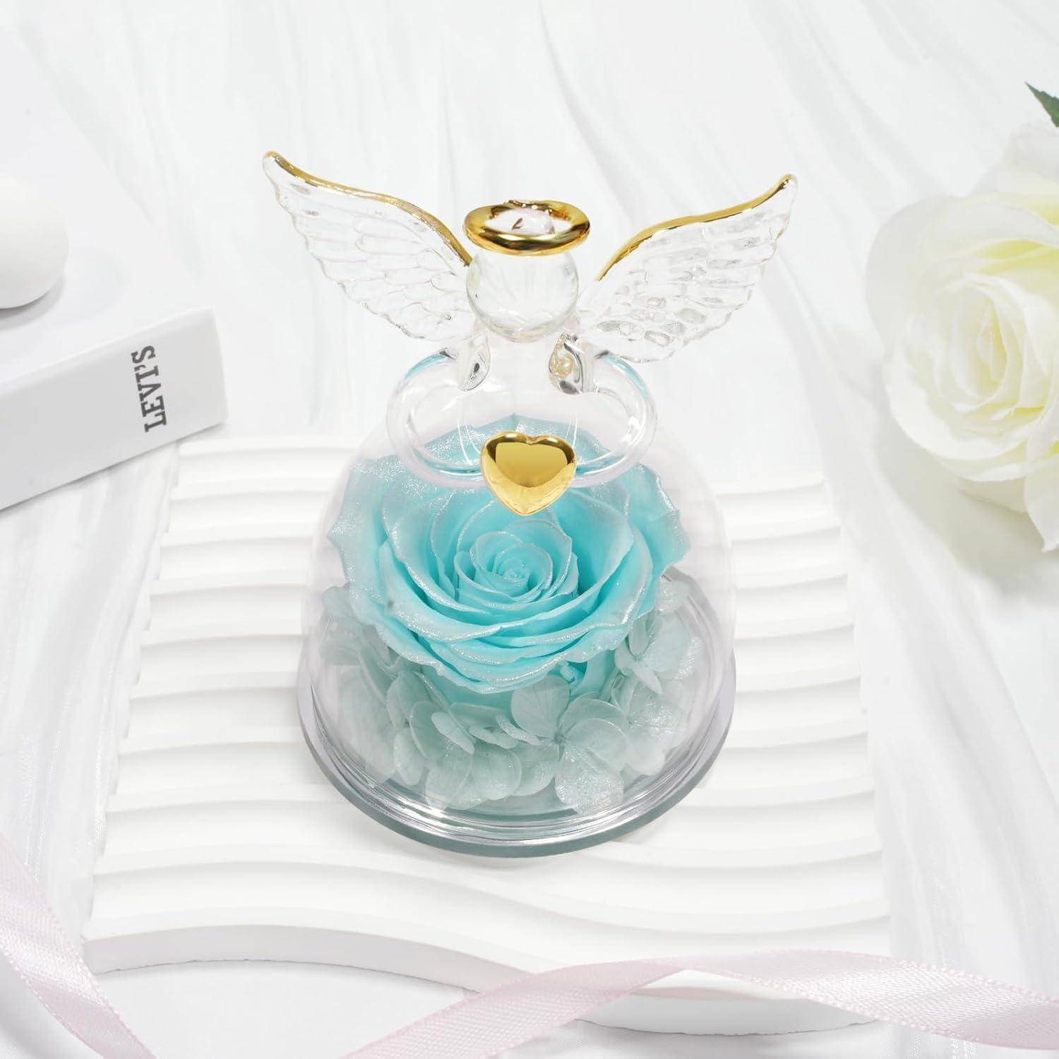 Glasenem Engelsfigur mit goldenen Flügeln und Herz, mit einer blauen Rose unter einer klaren Glaskuppel auf einer weißen Oberfläche.