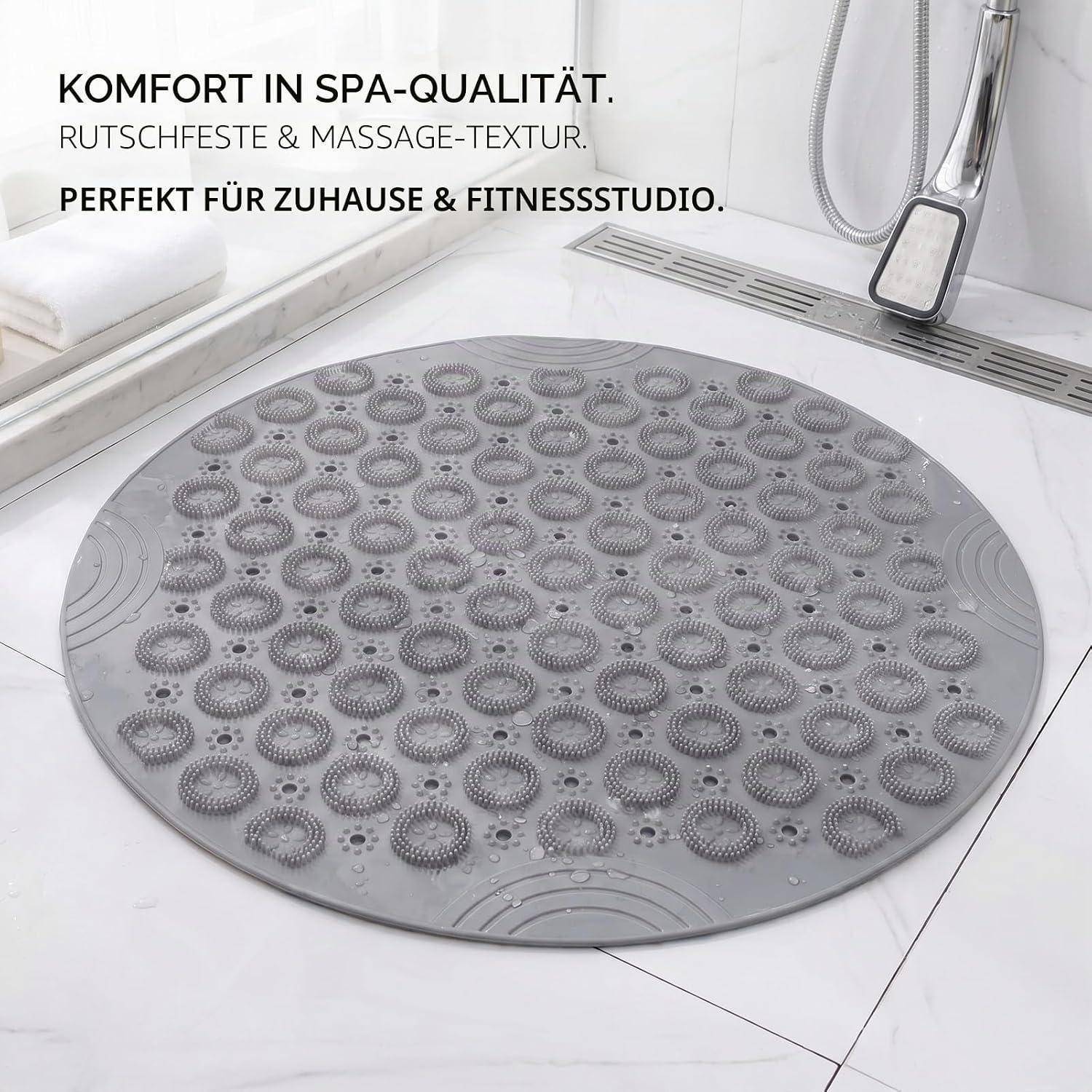 Runde graue Badematte mit Saugnapfeln und Massagestruktur in einem modernen Badezimmer, beschriftet auf Deutsch als „Komfort in Spa-Qualität