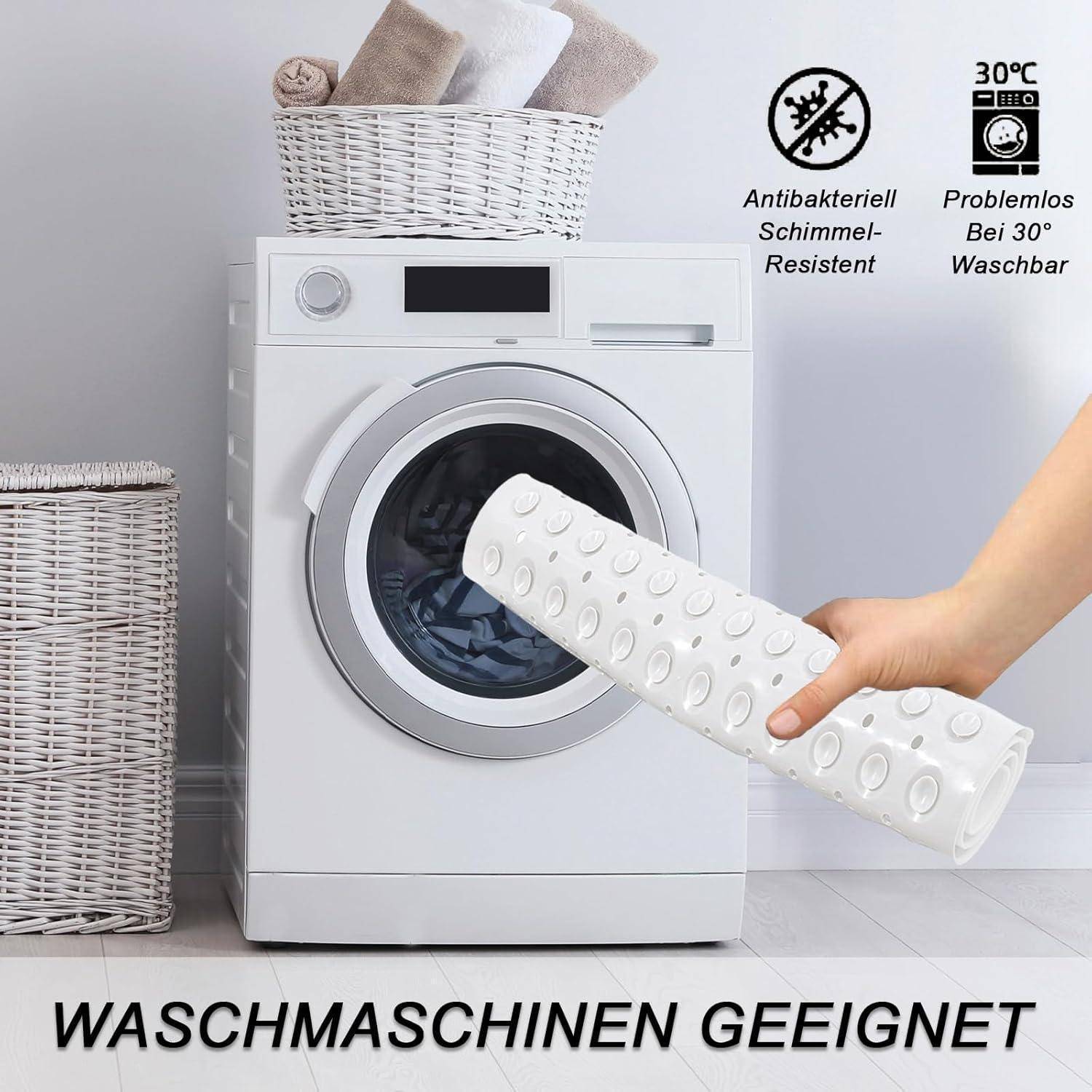 Weiße strukturierte rutschfeste Matte, die vor einer Waschmaschine gehalten wird; Text sagt „WASCHMASCHINEN GEEIGNET