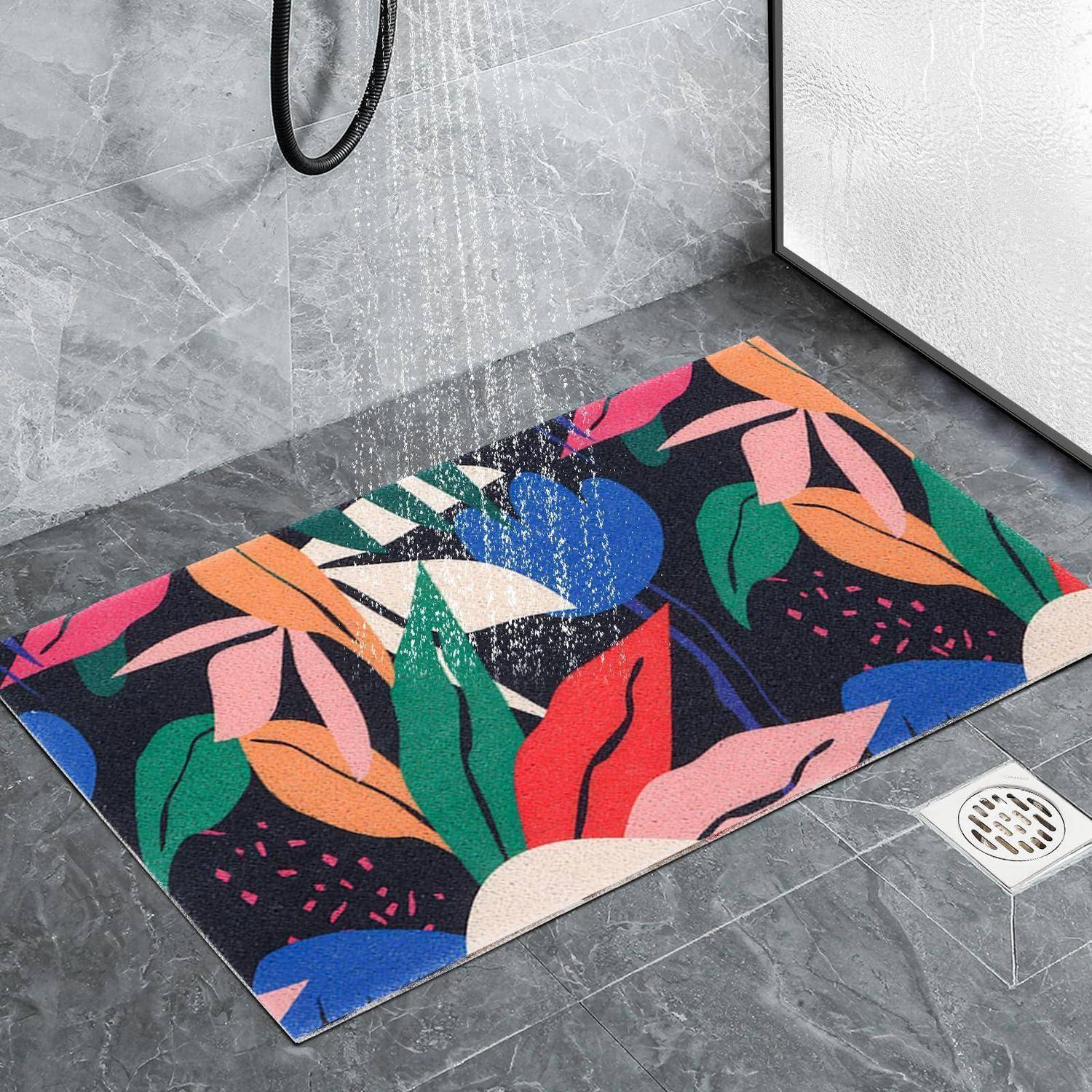 Farbenfrohe Badematte mit Blumenmuster in einer gefliesten Dusche, auf die Wasser in der Nähe eines Bodenablaufs fällt.