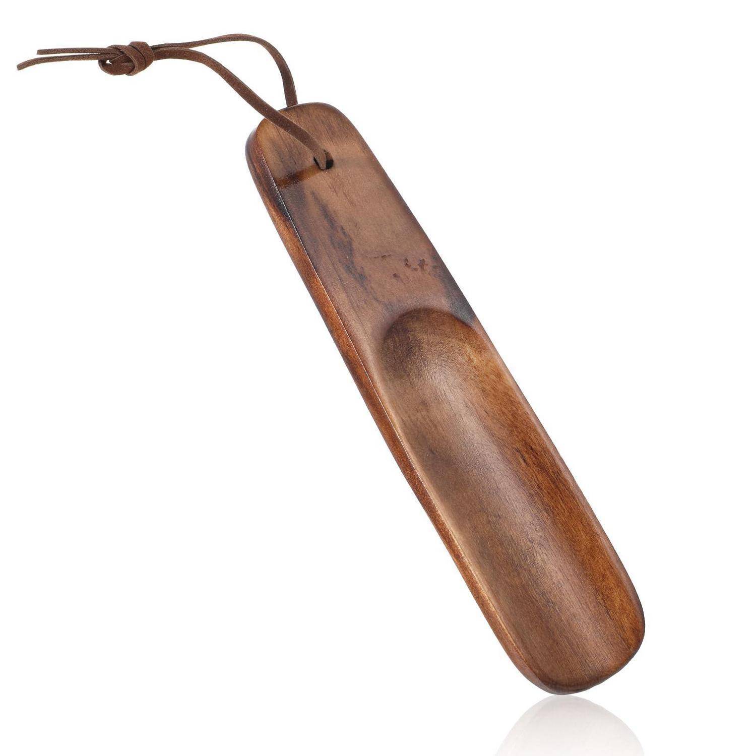 Ein Schuhlöffel aus Holz mit einer Lederband-Schlaufe, gezeigt vor weißem Hintergrund.