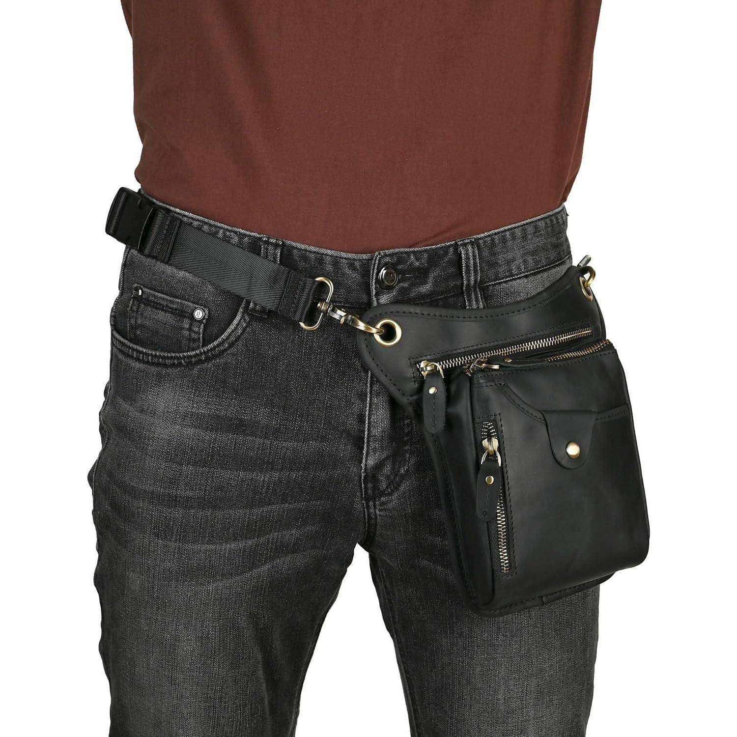 Nahaufnahme einer Person, die schwarze Jeans und einen Gürtel mit einer schwarzen Reißverschluss-Hüfttasche trägt, die an der Hüfte befestigt ist.