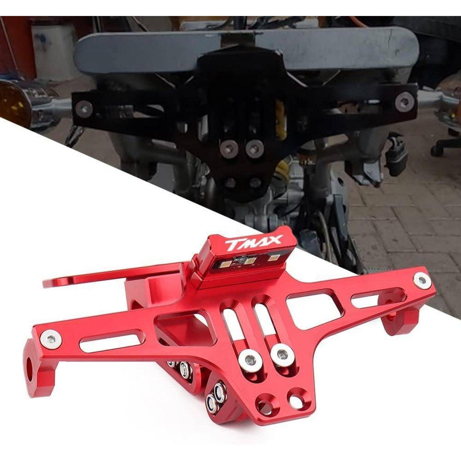 Rot eloxierter TMAX Motorrad-Hinterradschutz/Kennzeichen-Halter mit integrierter Lichthalterung, auf weißem Hintergrund mit unscharfem Motorrad dahinter gezeigt.