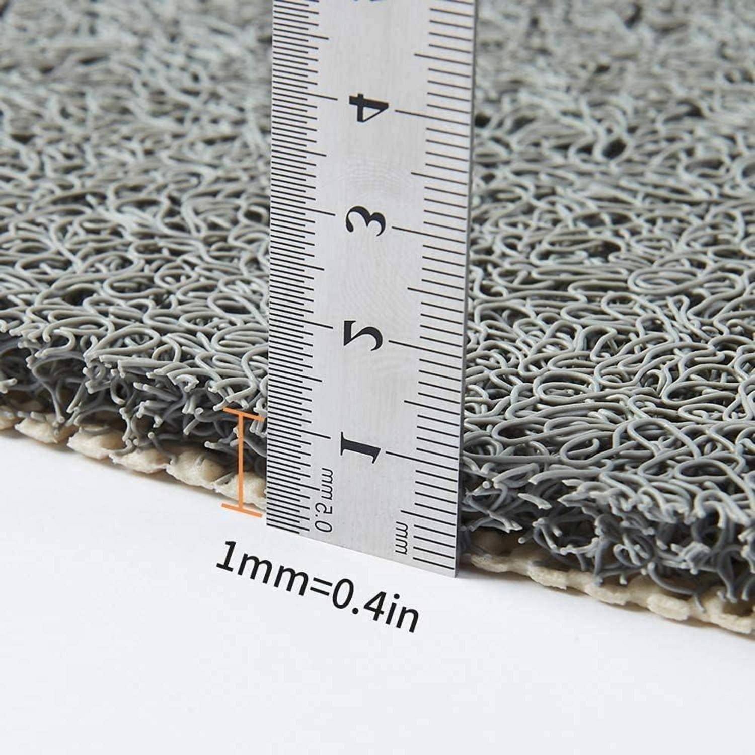 Nahaufnahme einer grauen strukturierten Matte mit einem Lineal, das ihre Dicke zeigt, mit der Beschriftung "1 mm = 0,4 Zoll"".