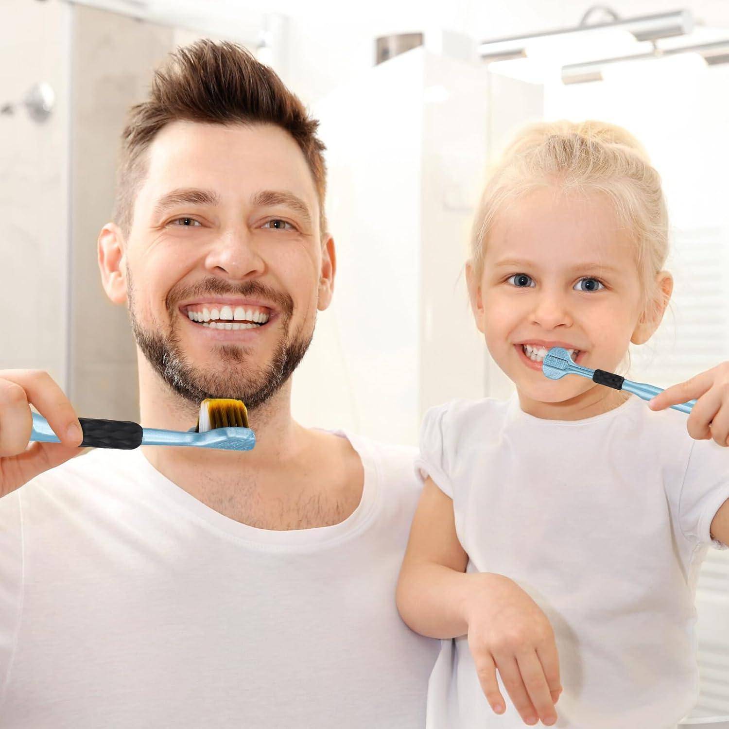 Lächelnder Vater und kleine Tochter putzen sich gemeinsam im hellen Badezimmer die Zähne, beide halten Zahnbürsten in den Händen.