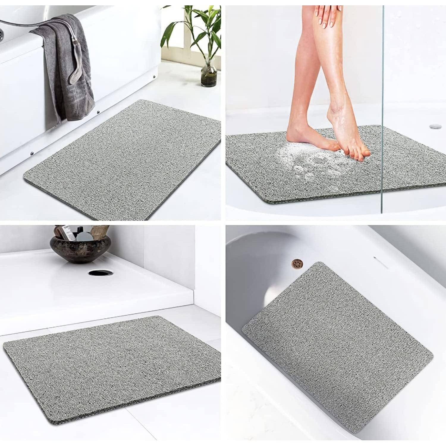 Graue saugfähige Badmatte in einem Badezimmer dargestellt, die Wasser von nassen Füßen aufnimmt und neben Dusche, Waschbecken und Wanne platziert ist.