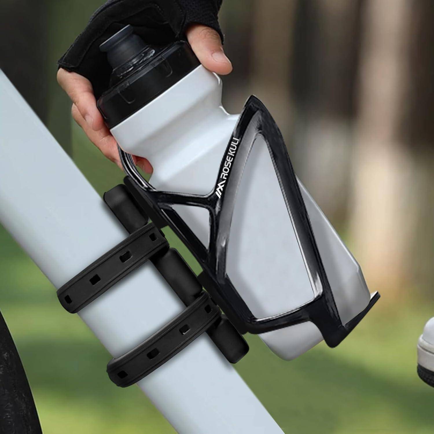 Hand, die eine Wasserflasche in einen montierten Fahrrad-Flaschenhalter einordnet, der an einem Rahmenrohr befestigt ist.