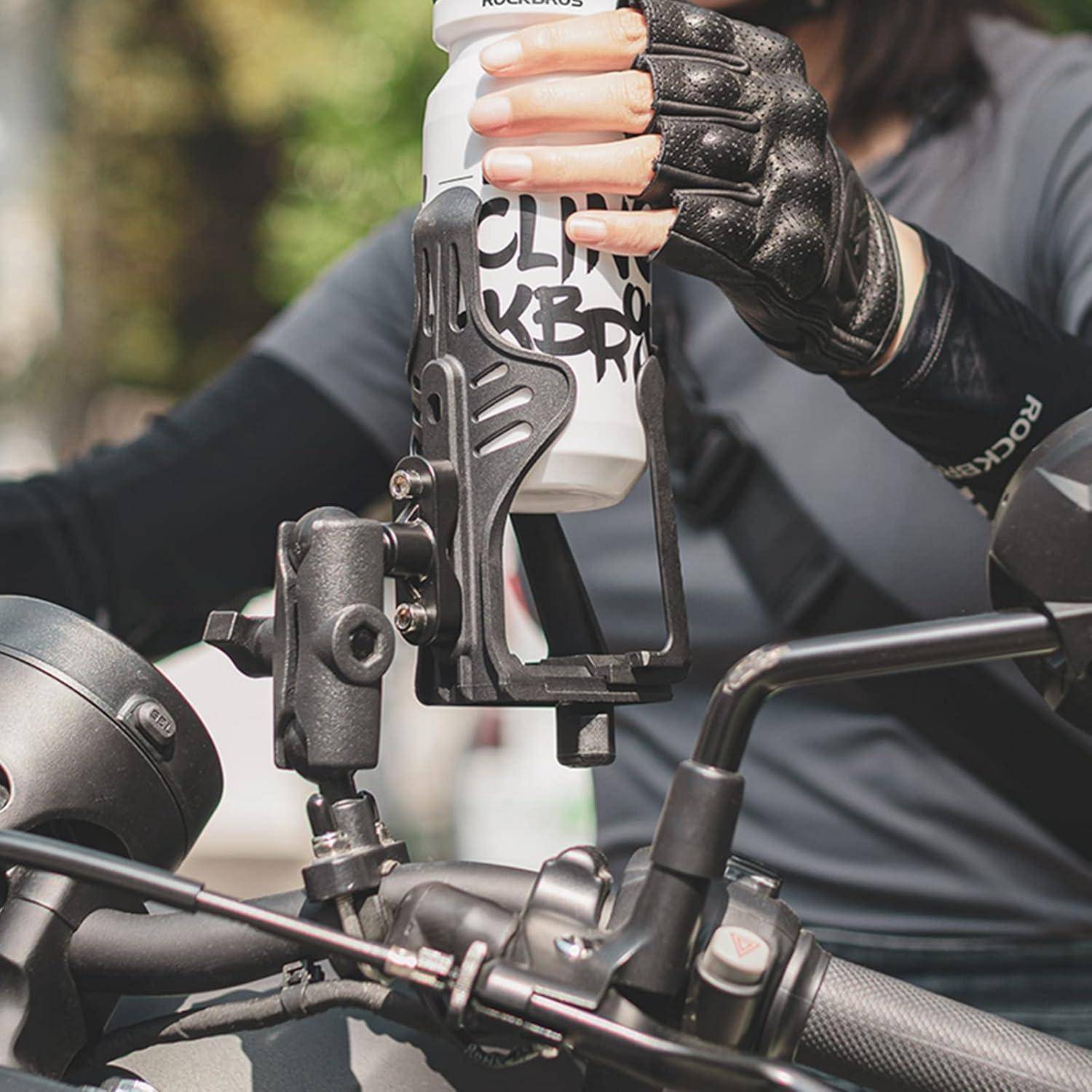 Ein handschuhgetragener Radfahrer stellt eine Wasserflasche in einen an der Lenkstange montierten Flaschenhalter auf einem Fahrrad.
