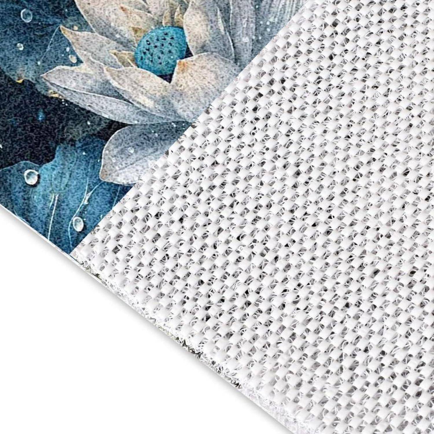 Nahaufnahme eines strukturierten weißen Gewebestoffs mit bedrucktem blauem Blumensaum, der das Material und das dekorative Muster zeigt.
