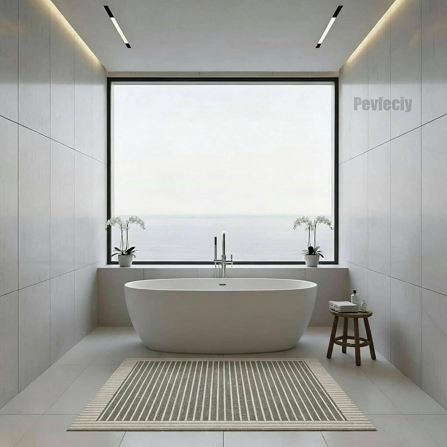 Minimalistisches Badezimmer mit freistehender ovaler Badewanne, zentral vor einem großen Fenster mit Blick auf ruhiges Wasser positioniert, flankiert von Topforchideen und einem kleinen Hocker.