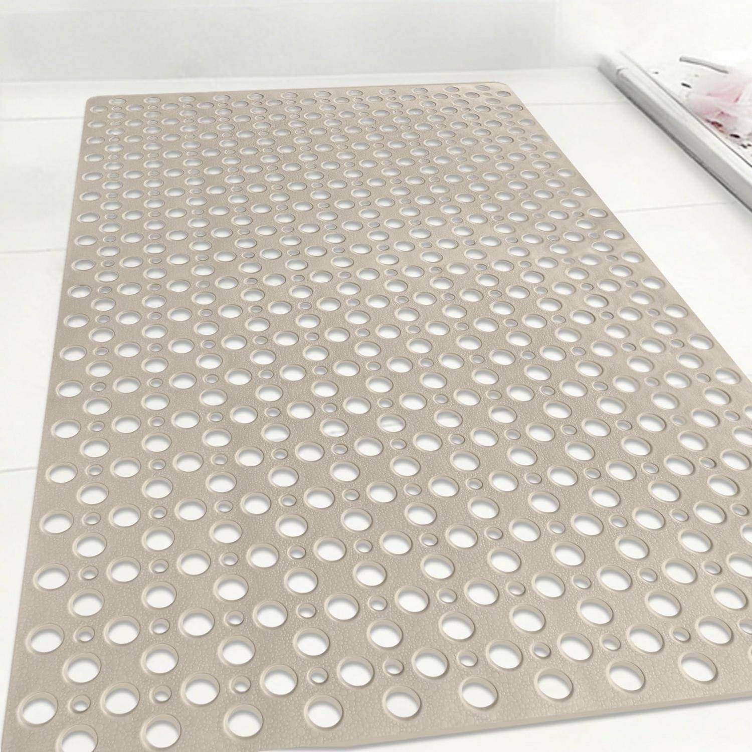 Beige-farbene Gummi-Antirutschmatte mit Reihen von runden Löchern auf einem weißen Boden an einer Wand.