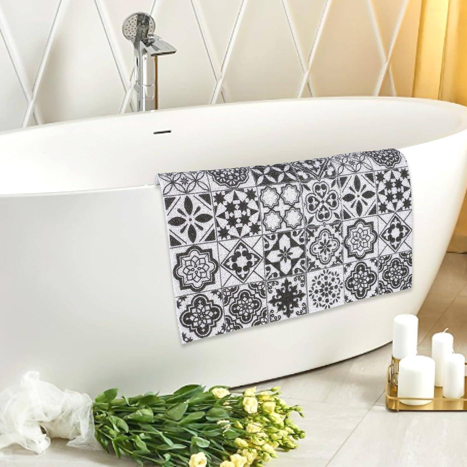 Freistehende weiße Badewanne mit gemustertem Handtuch, Tulpenstrauß und Badkerzen in einem hellen Badezimmer.