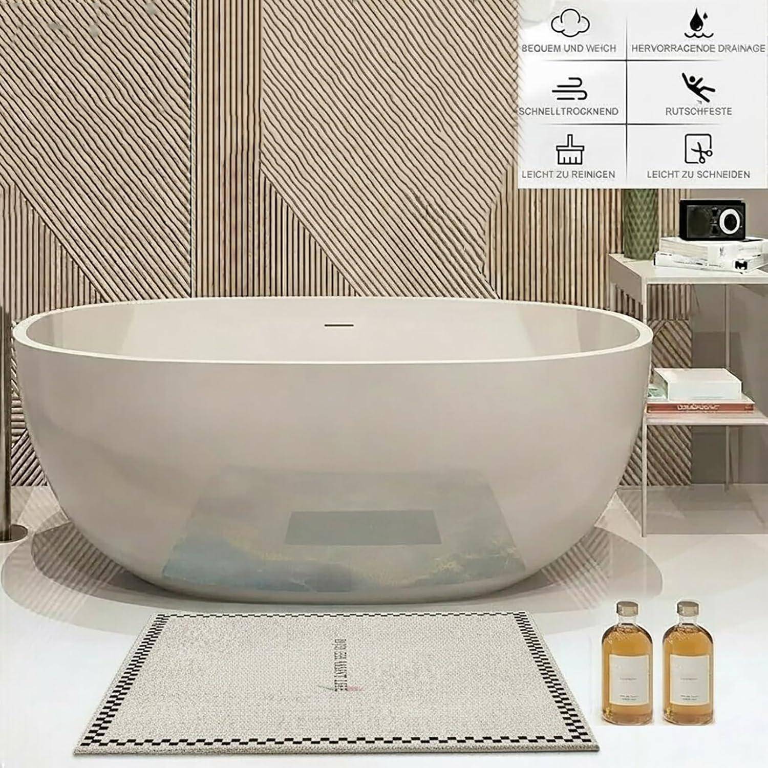 Moderne freistehende Badewanne in Ovalform in einer minimalistischen Badezimmerausstellung, mit zwei Flaschen und einer Badematte davor; Funktionssymbole in der Ecke heben Produktvorteile hervor.