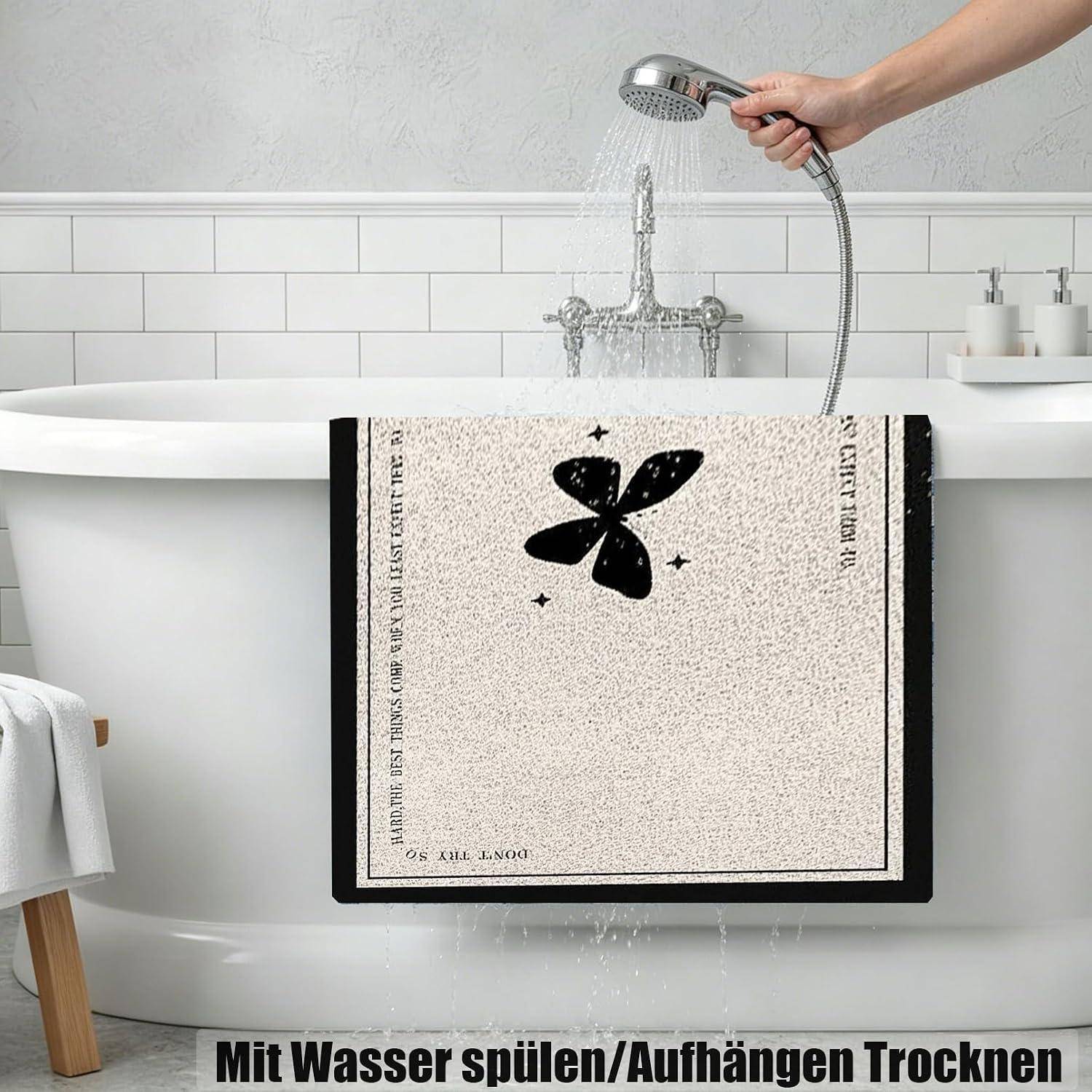 Badetuch, das auf der Wanne zum Trocknen hängt, während es mit einer Handbrause gespült wird; deutscher Text besagt „Mit Wasser spülen/Aufhängen Trocknen.