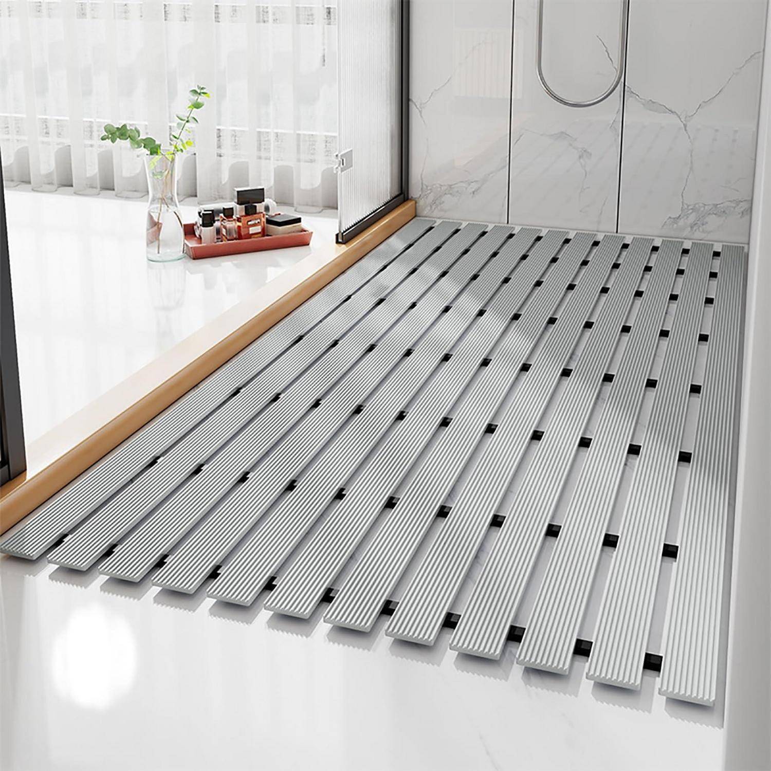 Modernes Badezimmer mit einer großen silbernen Duschmatte mit Lamellen neben einem Fenster, mit Toilettenartikeln und einer Vase im Hintergrund.