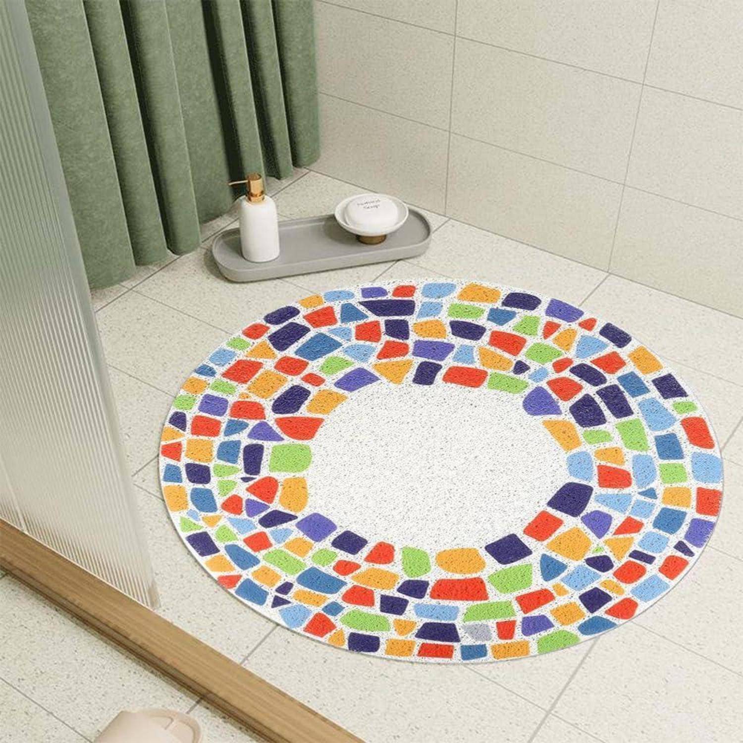 Bunter runder Teppich im Mosaik-Stil auf einem hellen gekachelten Boden neben einem grünen Vorhang und einem Tablett mit einer Flasche und einer Schale.