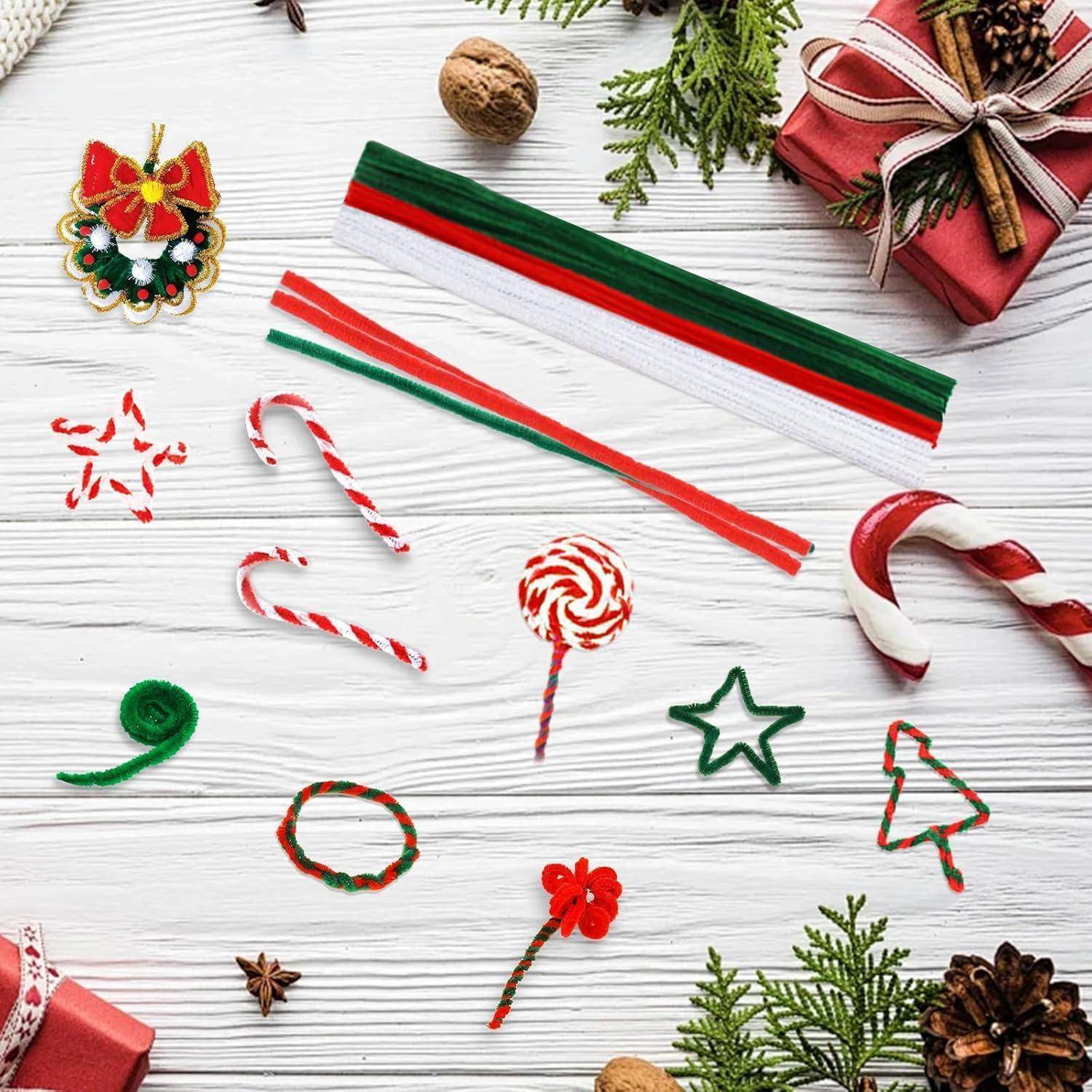 Sortierte Weihnachtsbastelmaterialien und Dekorationen auf weißem Holzhintergrund, einschließlich Bänder, Zuckerstangen, Sterne und Geschenkboxen.