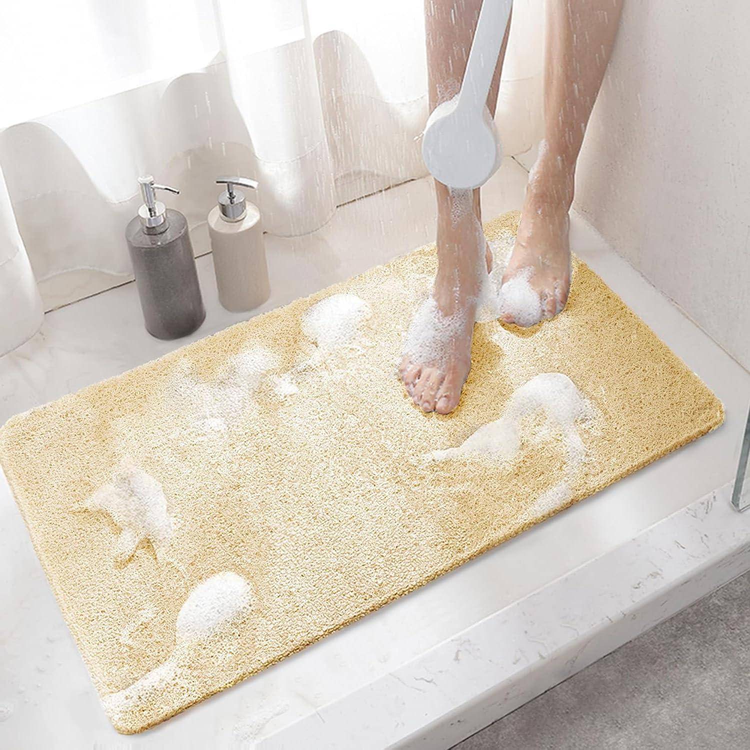 Person, die Füße in einer Dusche auf einer gelben Badematte mit Seifenschaum und Spendern in der Nähe wäscht.