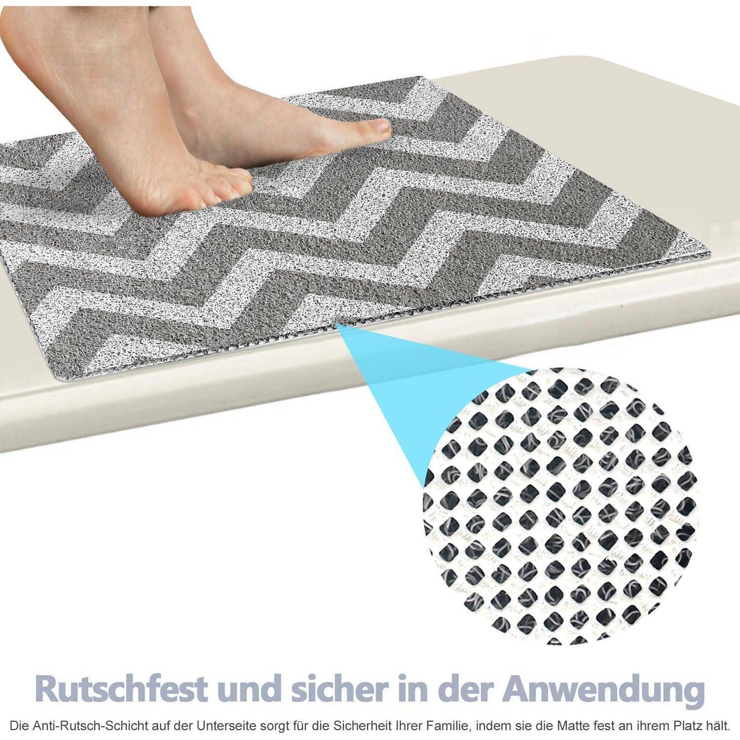 Nackte Füße stehen auf einer grauen Zickzack-Antirutschmatte auf einer Stufe, mit einer vergrößerten Einfügung, die ihre strukturierte Griffoberfläche zeigt und deutscher Text über sichere Verwendung.