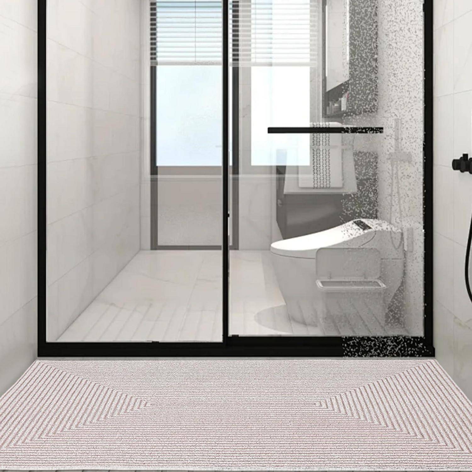 Modernes weißes Badezimmer mit schwarzem Glasgehäuse, Regendusche, wandmontiertem Toilet und gestreiftem Badezimmerteppich im Vordergrund.