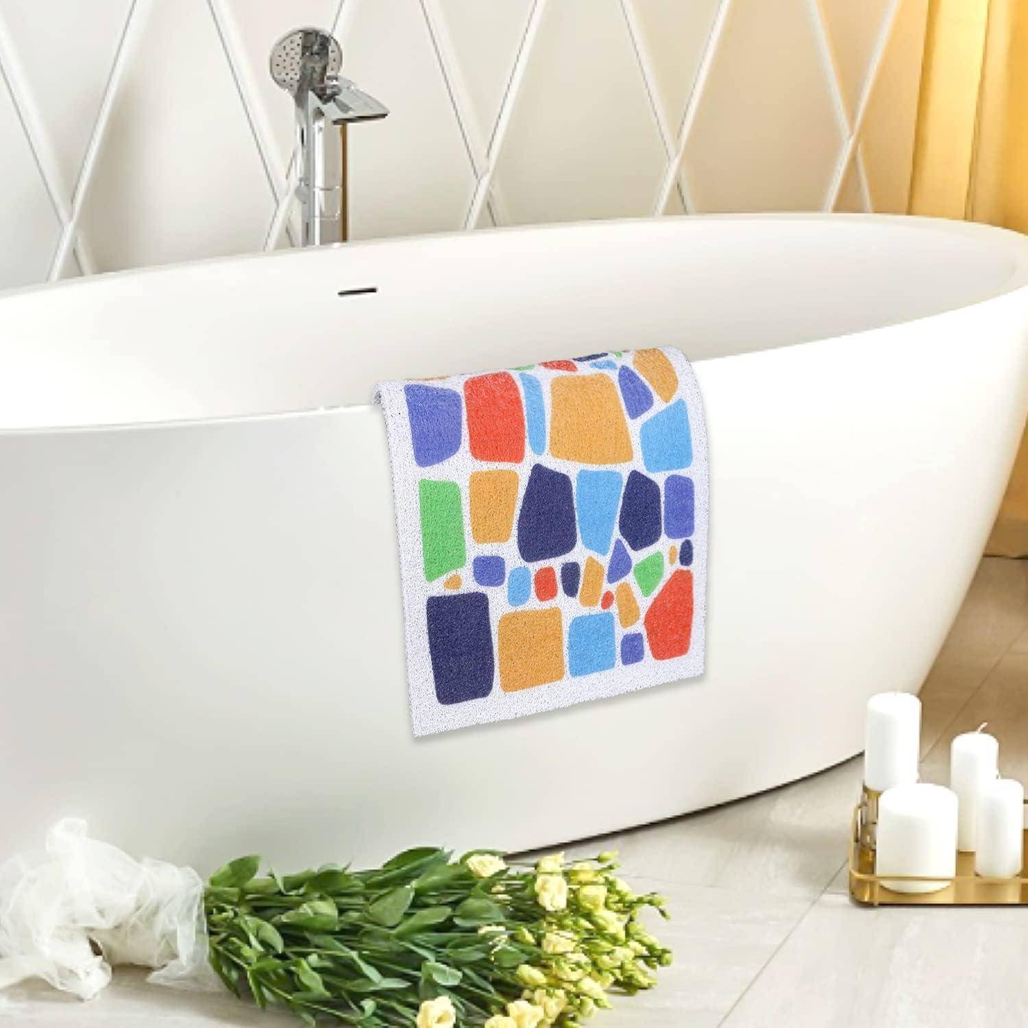 Modernes weißes freistehendes Badewanne mit buntem geometrischem Handtuch drapiert darüber, mit Blumen und Kerzen auf dem Badezimmerboden.