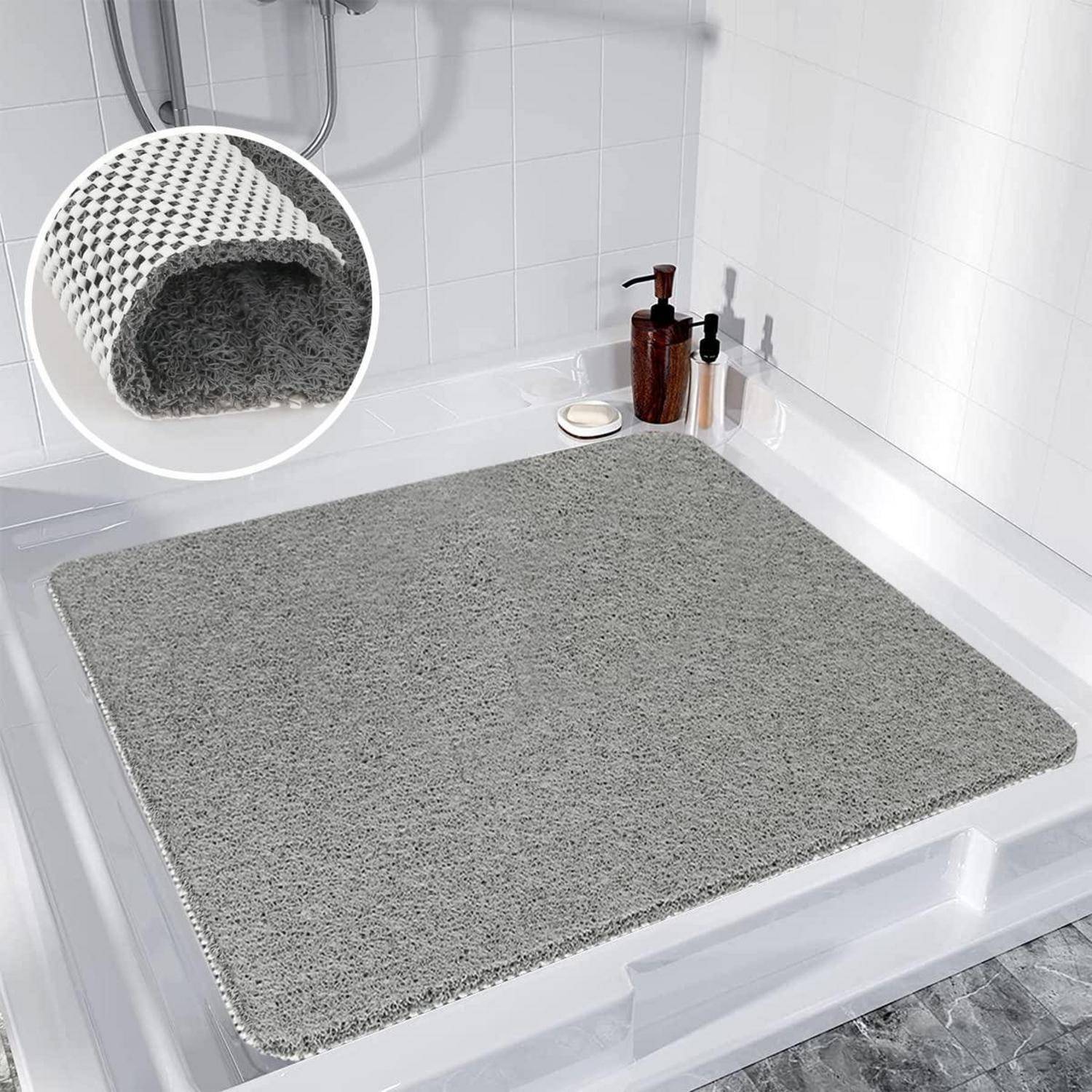 Graue strukturierte Badematte in einer weißen Dusche oder Wanne, gezeigt mit einer Nahaufnahme des saugfähigen gewebten Untergrundes.