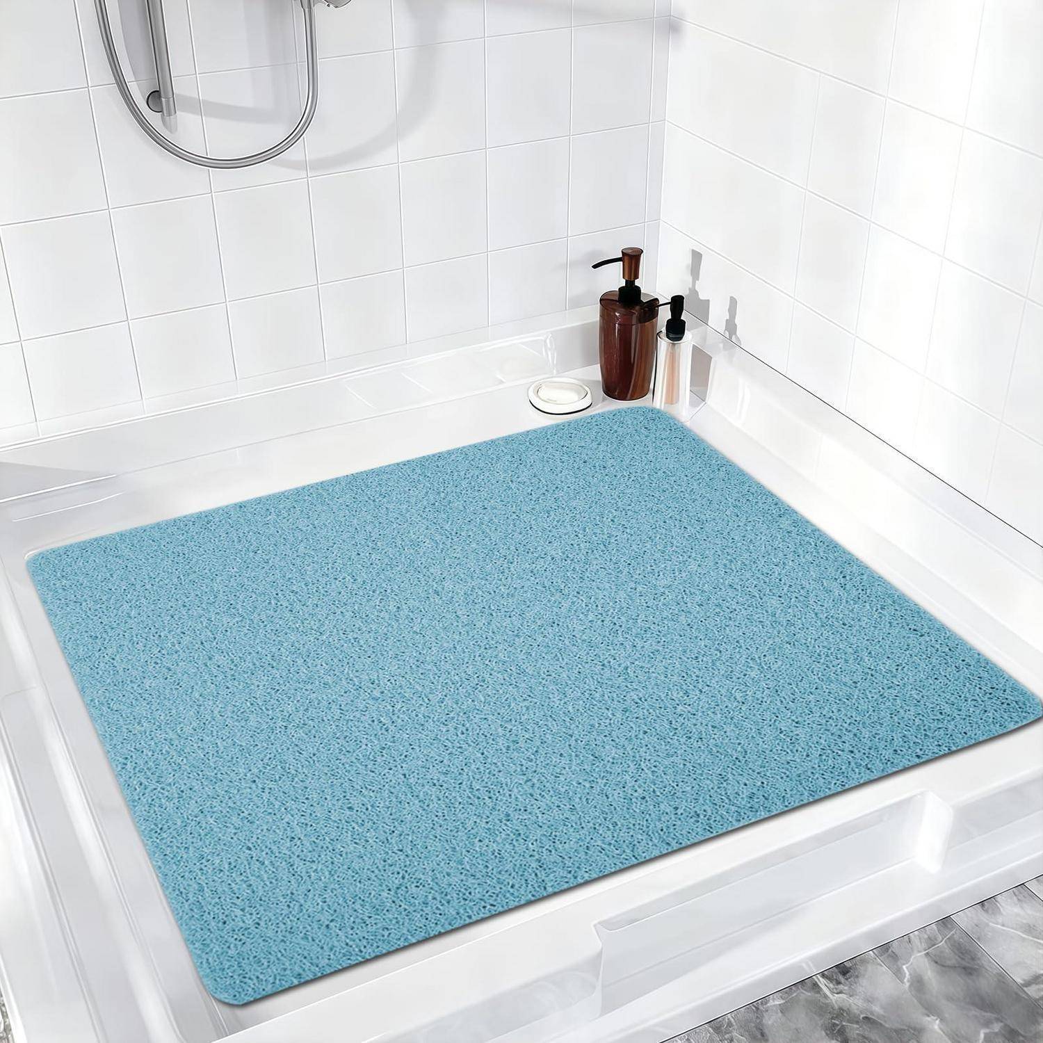 Blaugefleckte Badematte, die den Boden einer weißen Dusche oder Badewanne bedeckt, mit Seifenspendern auf der Ablage.
