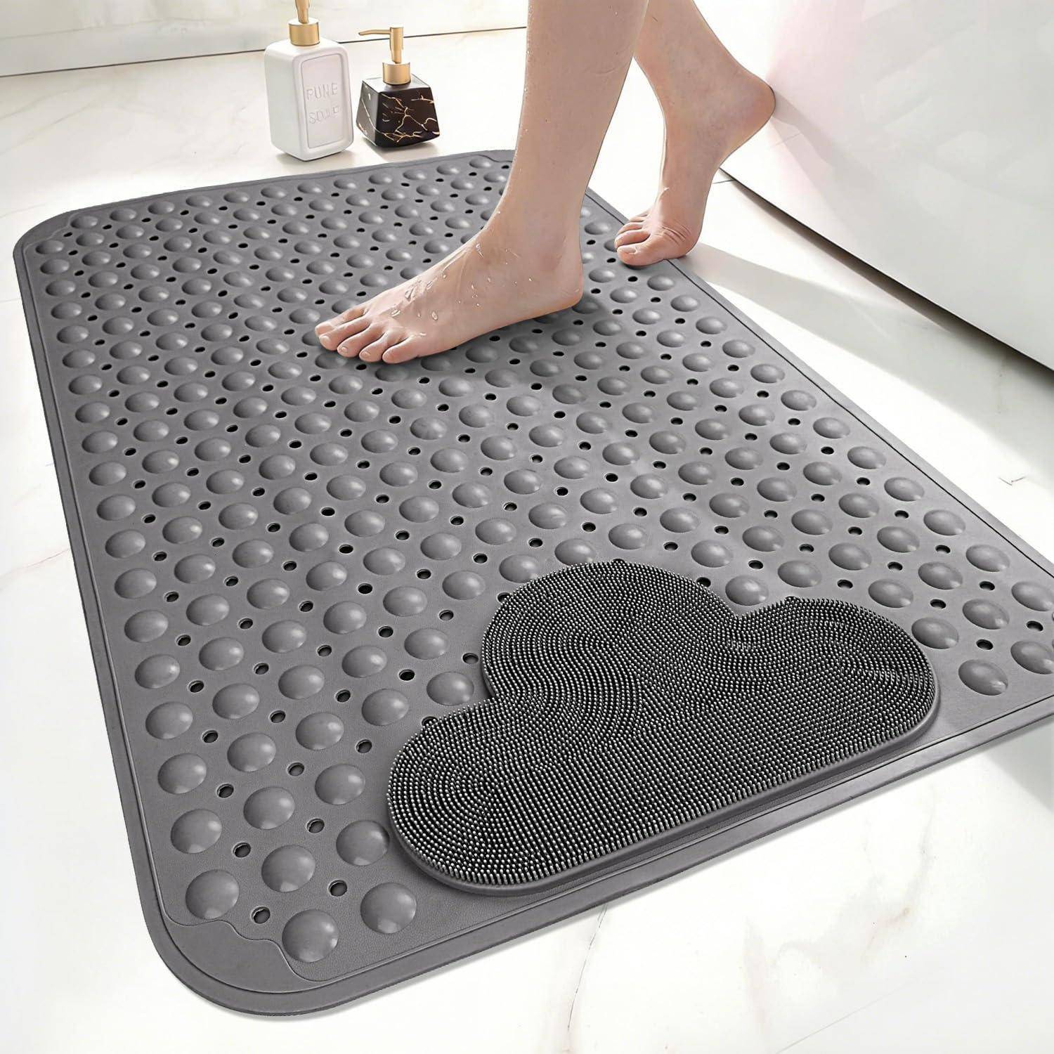 Barfüße stehen auf einer grauen strukturierten Badematte mit einem schwarzen wolkenförmigen Peelingpad in einem Badezimmer.
