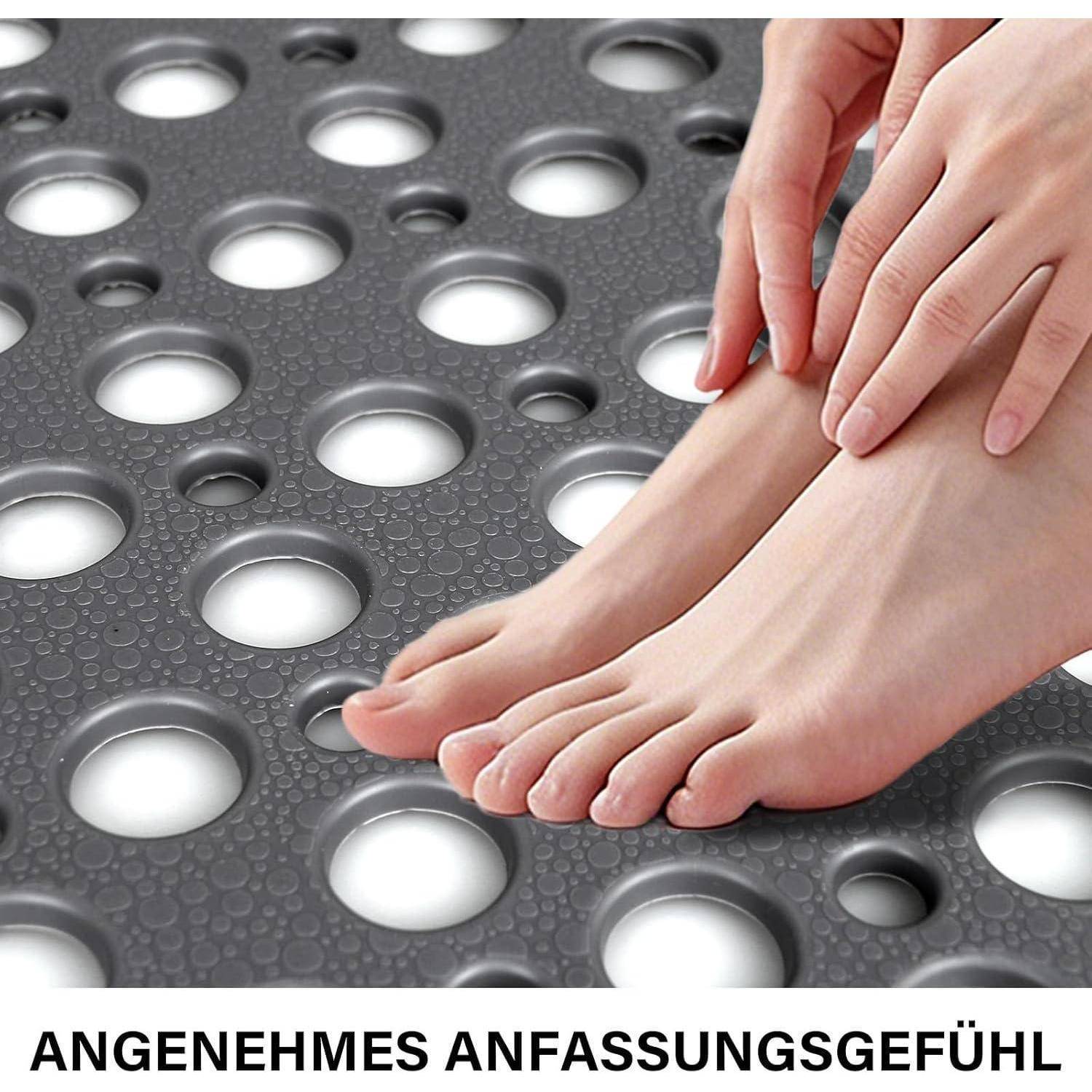 Nahaufnahme von bloßen Füßen, die eine strukturierte, perforierte Matte berühren, was ein angenehmes Tastgefühl veranschaulicht; deutscher Text lautet „ANGENEHMES ANFASSUNGSGEFÜHL