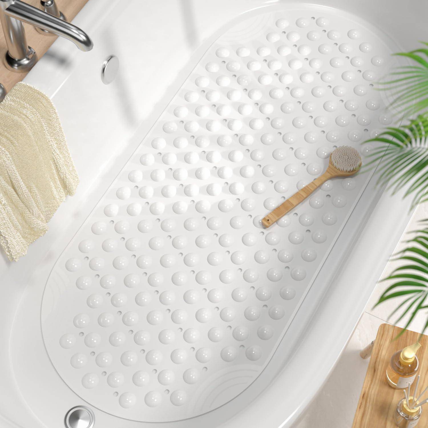 Weiße rutschfeste Badewannenmatte mit Saugnapfen, eine Badebürste mit Holzgriff und ein in der Nähe aufgehängtes Handtuch in einem hellen Badezimmer.