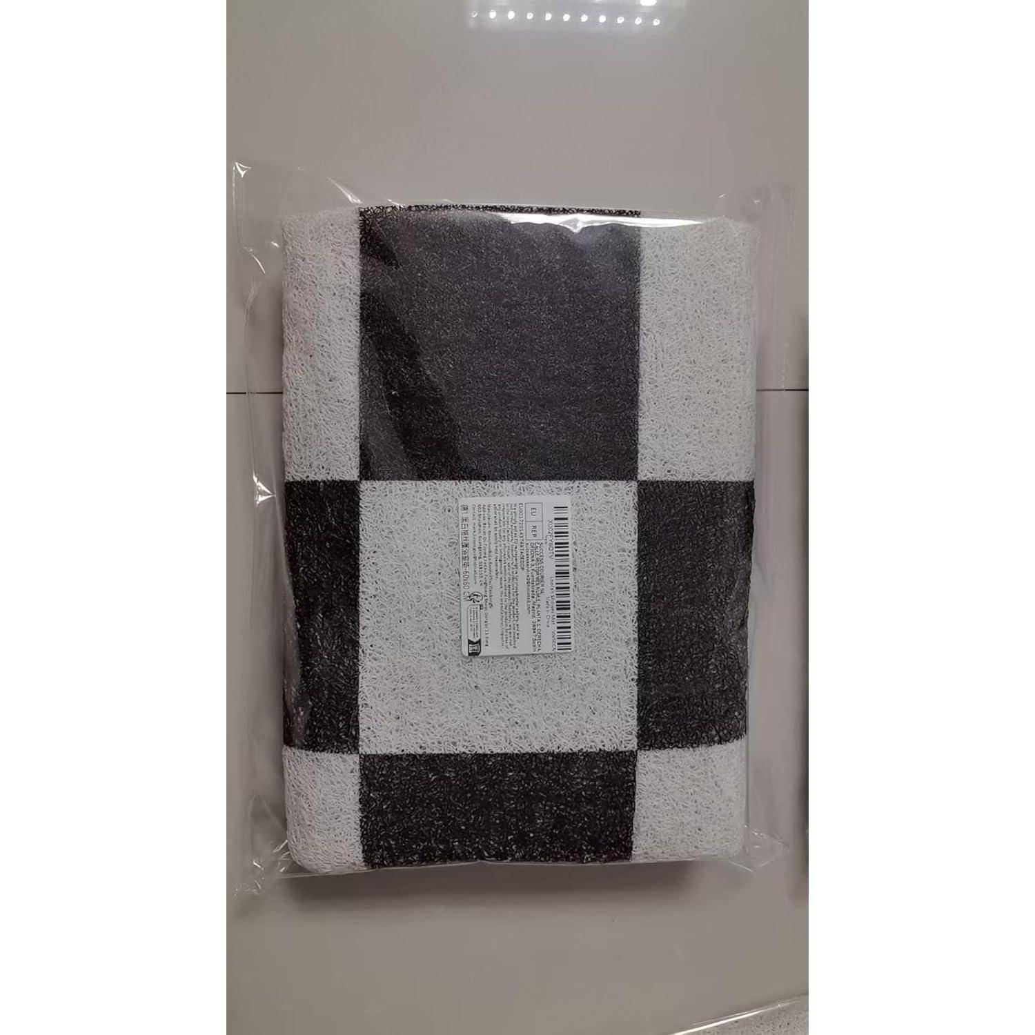 Verpackte schwarz-weiß karierte Decke oder Handtuch in durchsichtigem Kunststoff verschlossen mit einem Produktetikett in der Mitte der Vorderseite.