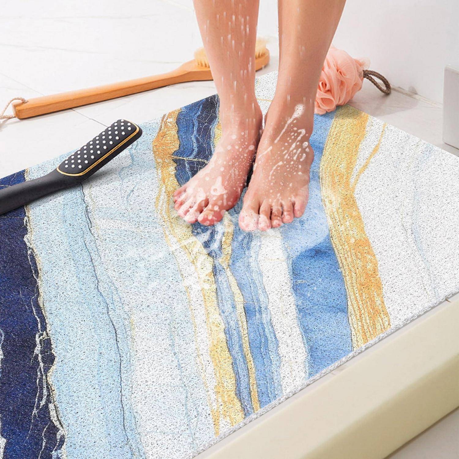 Person wäscht nackte Füße in einer Dusche auf einer farbenfrohen Badmatte, mit einer Bürste und einem Handtuch in der Nähe.