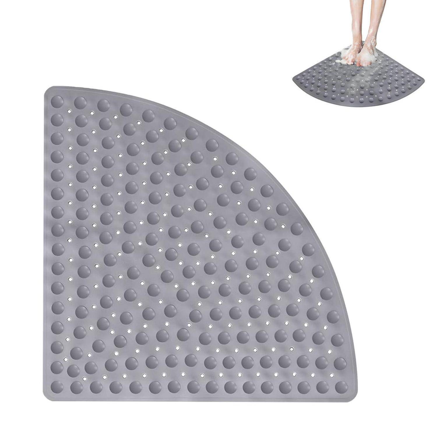 Graue Viertelkreis-Badematte mit rutschfester Oberfläche und erhabenen saugnapfähnlichen Noppen, gezeigt mit Füßen, die darauf in einer Dusche oder Badewanne stehen.