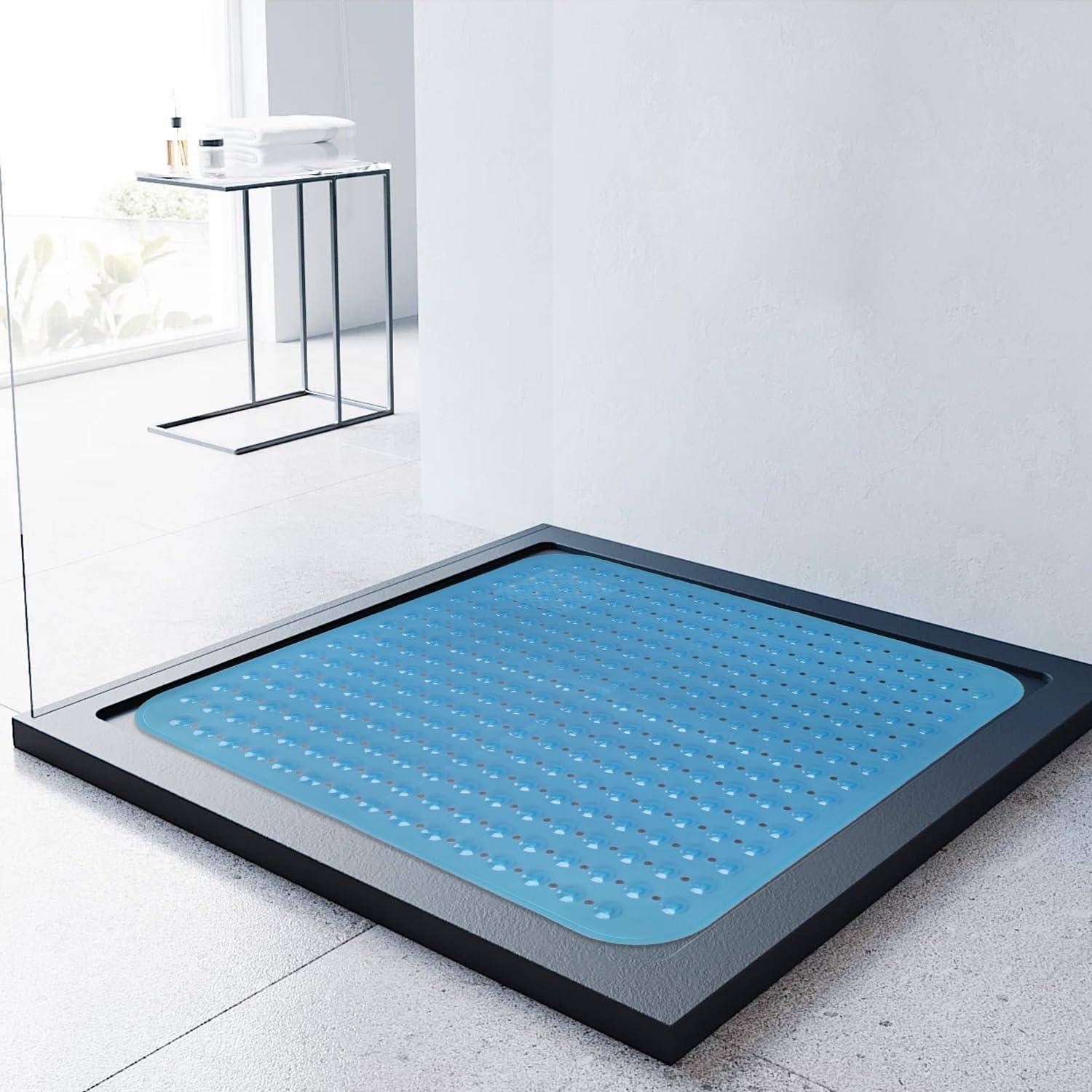 Blauefußmatte in einem schwarzen Rahmen auf einem Badezimmerboden, mit einem kleinen Beistelltisch und Toilettenartikeln im Hintergrund.