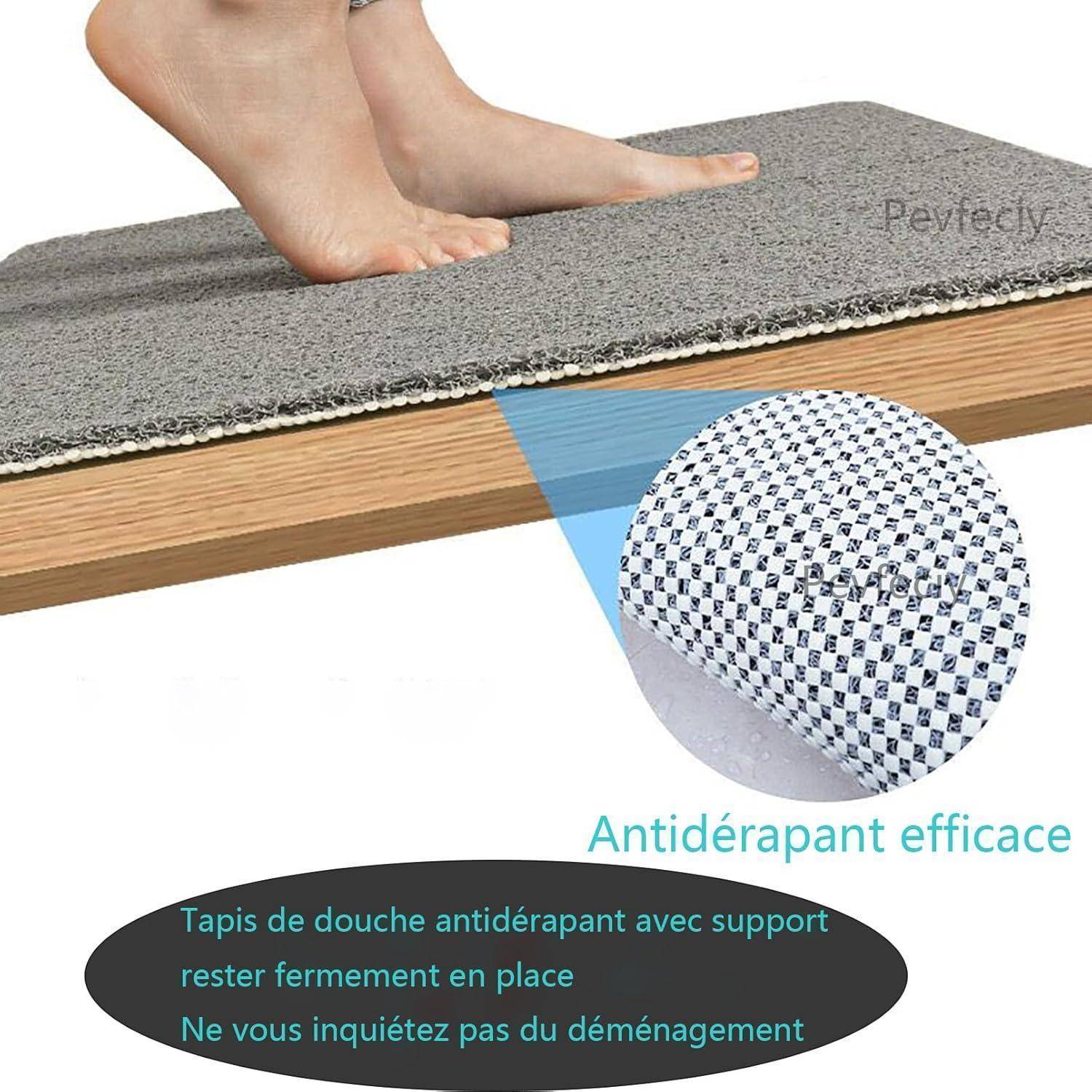 Fuß tritt auf eine graue rutschfeste Duschmatte auf einem Holzboden, mit einer Nahaufnahme, die ihre strukturierte Rückseite und französischen Text über sicheres Halt zeigt.