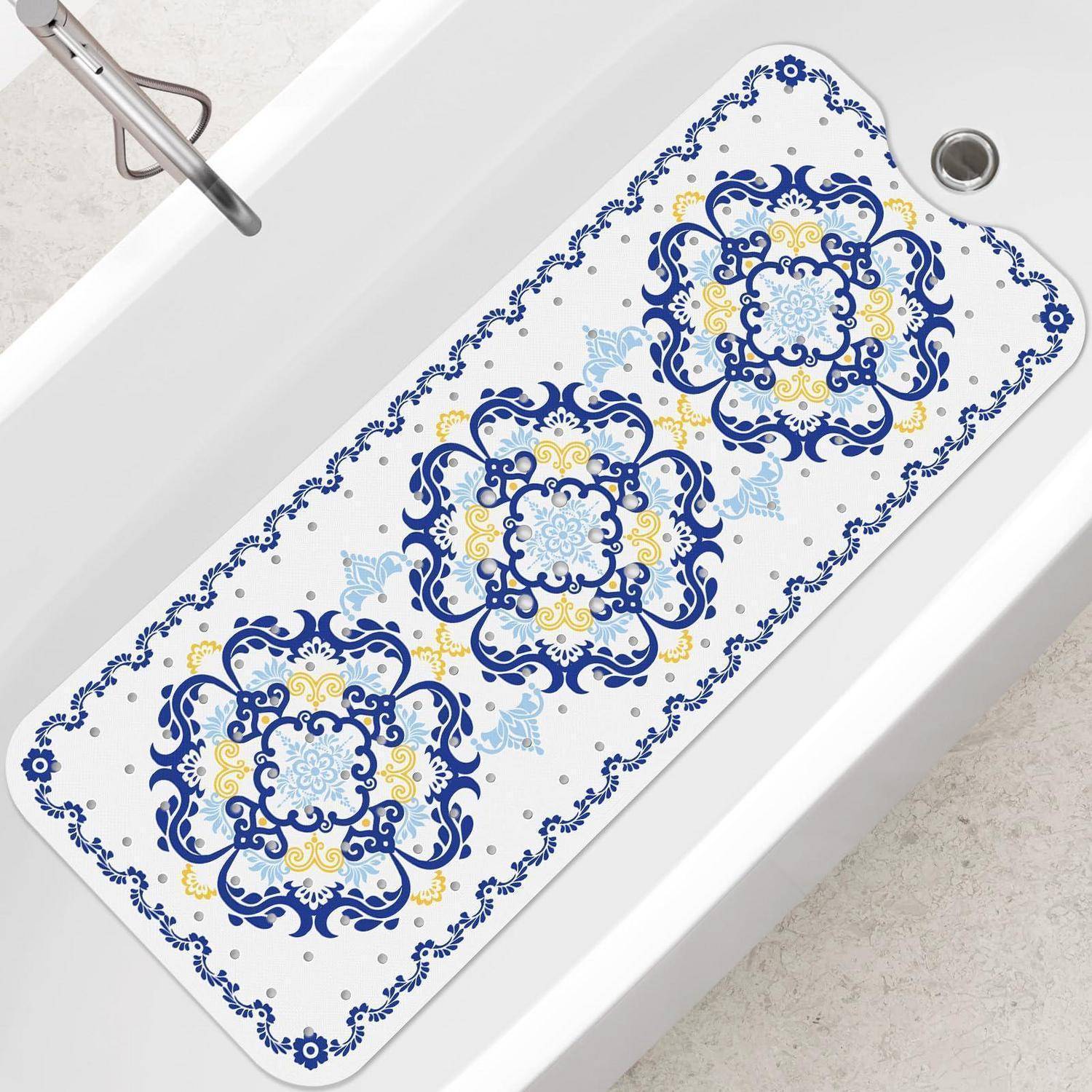 Weiße Badmatte mit blauem und gelbem verziertem Blumenkachel-Muster, ausgelegt über einer Badewanne.