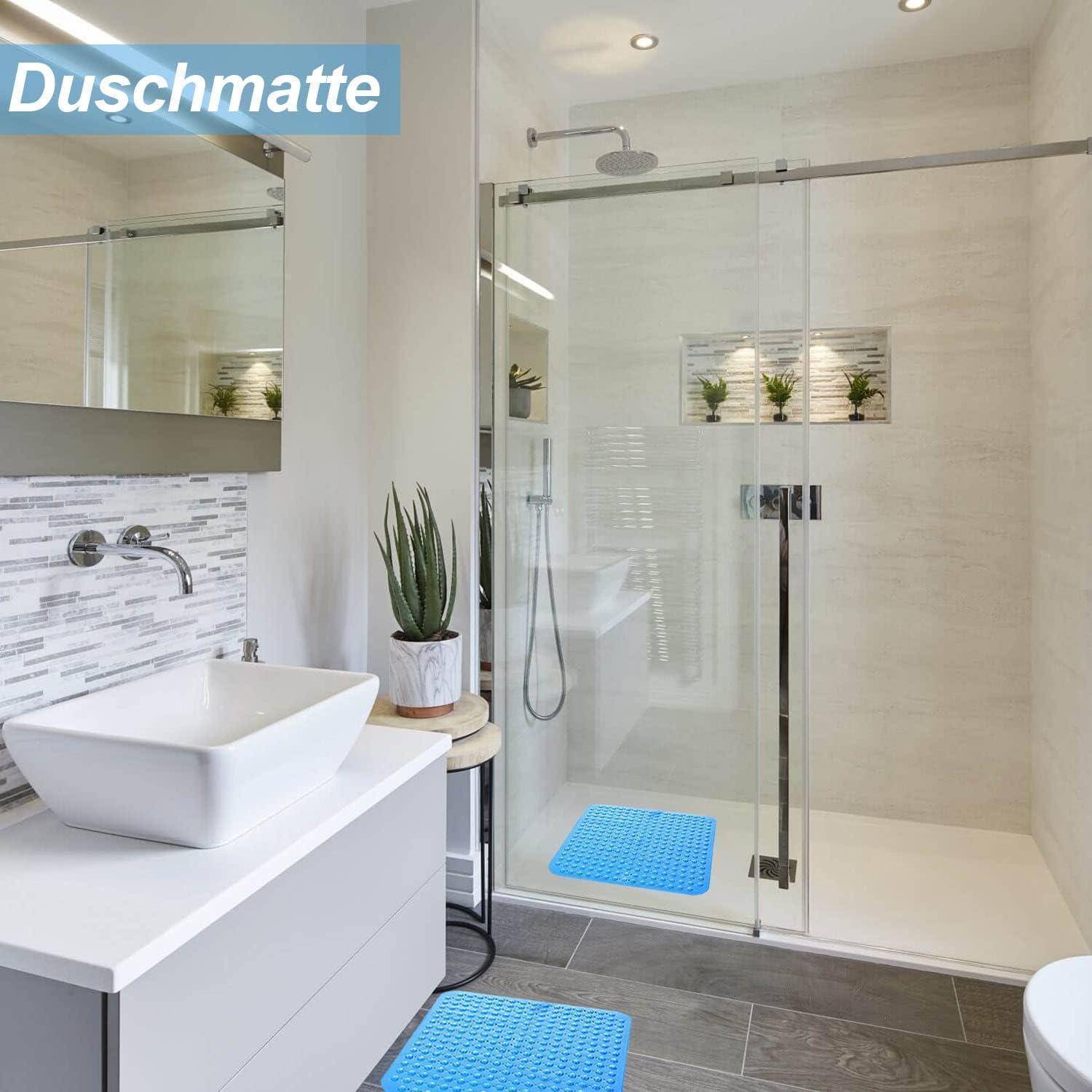 Modernes Badezimmer mit begehbarer Glasdusche, weißem Waschtisch und Waschbecken, Spiegel, Topfpflanze und blauen Badematten; Textoverlay 
