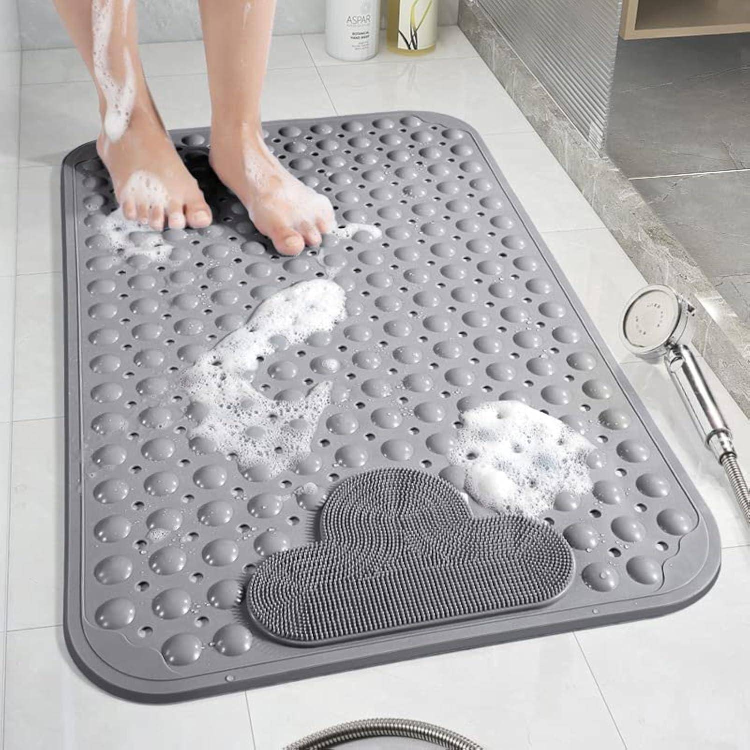 Füße waschen auf einer grauen rutschfesten Badewannenmatte in einer Dusche, mit Seifenschaum und einem Handbrausekopf in der Nähe.