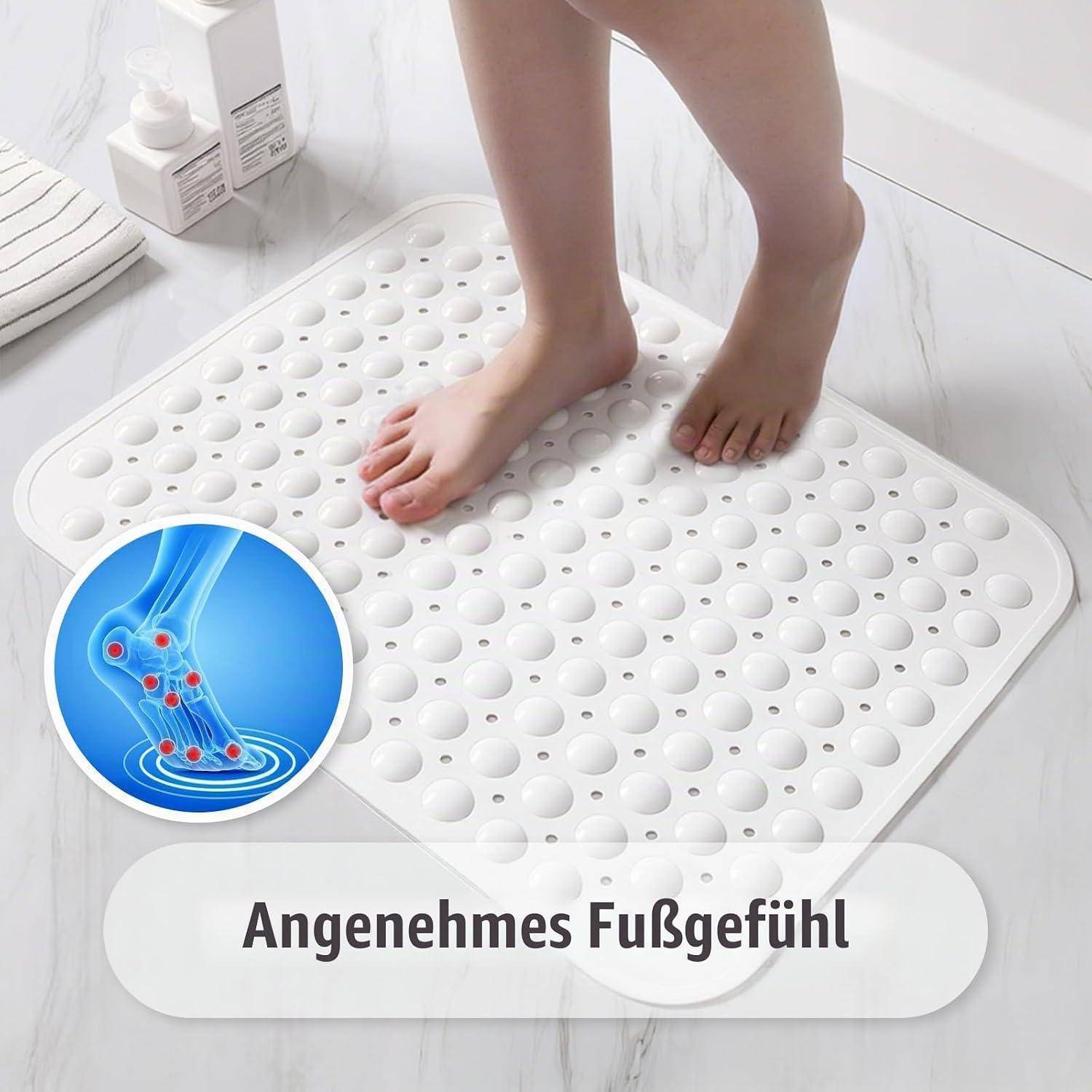 Füße stehen auf einer weißen rutschfesten Badmatte mit Saugnäpfen; eingefügte Grafik zeigt Druckentlastung für die Füße. Der Text besagt „Angenehmes Fußgefühl".