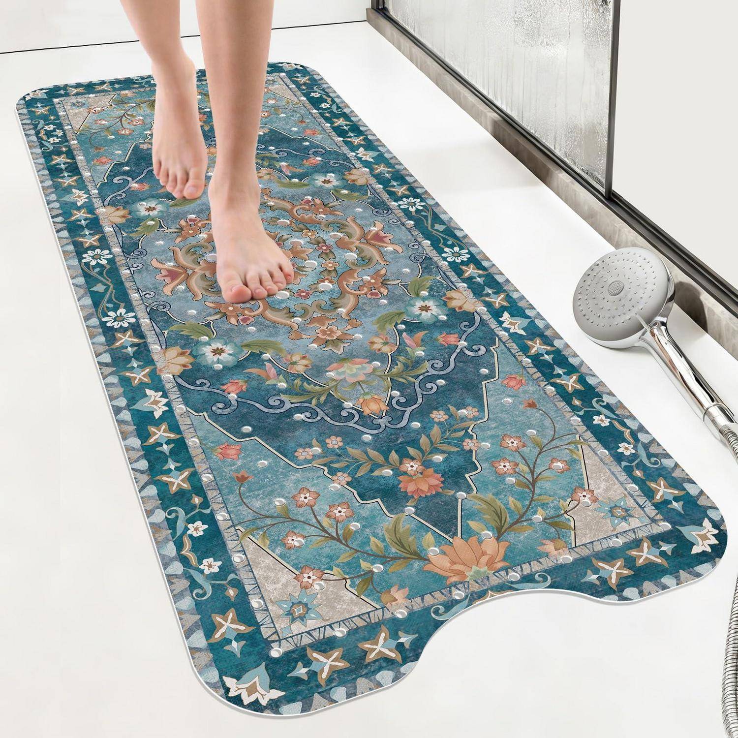 Nackte Füße stehen auf einer dekorativen blauen Blumenbadematte neben einem Duschkopf und einer gläsernen Duschwand.