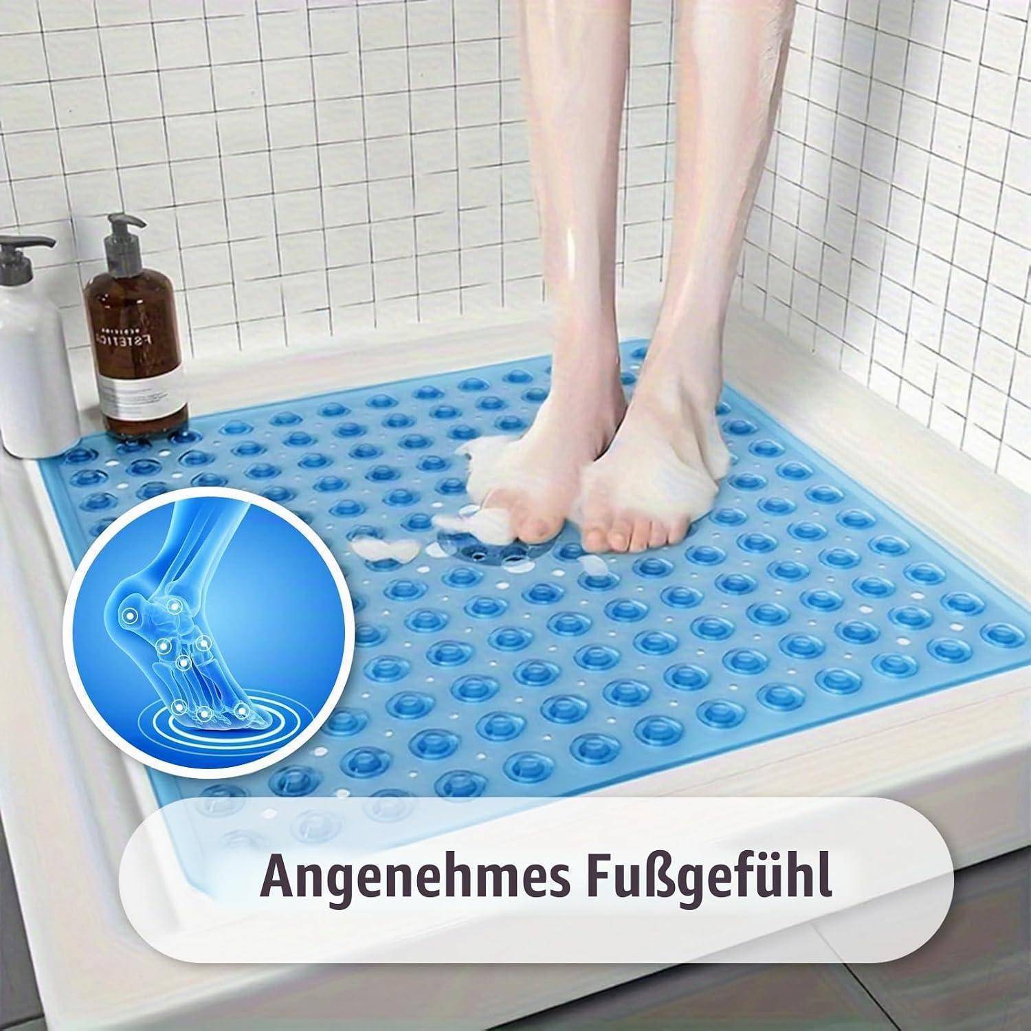 Füße, die auf einer blauen Saugnapf-Badmatte in einer Dusche stehen, mit dem deutschen Text „Angenehmes Fußgefühl