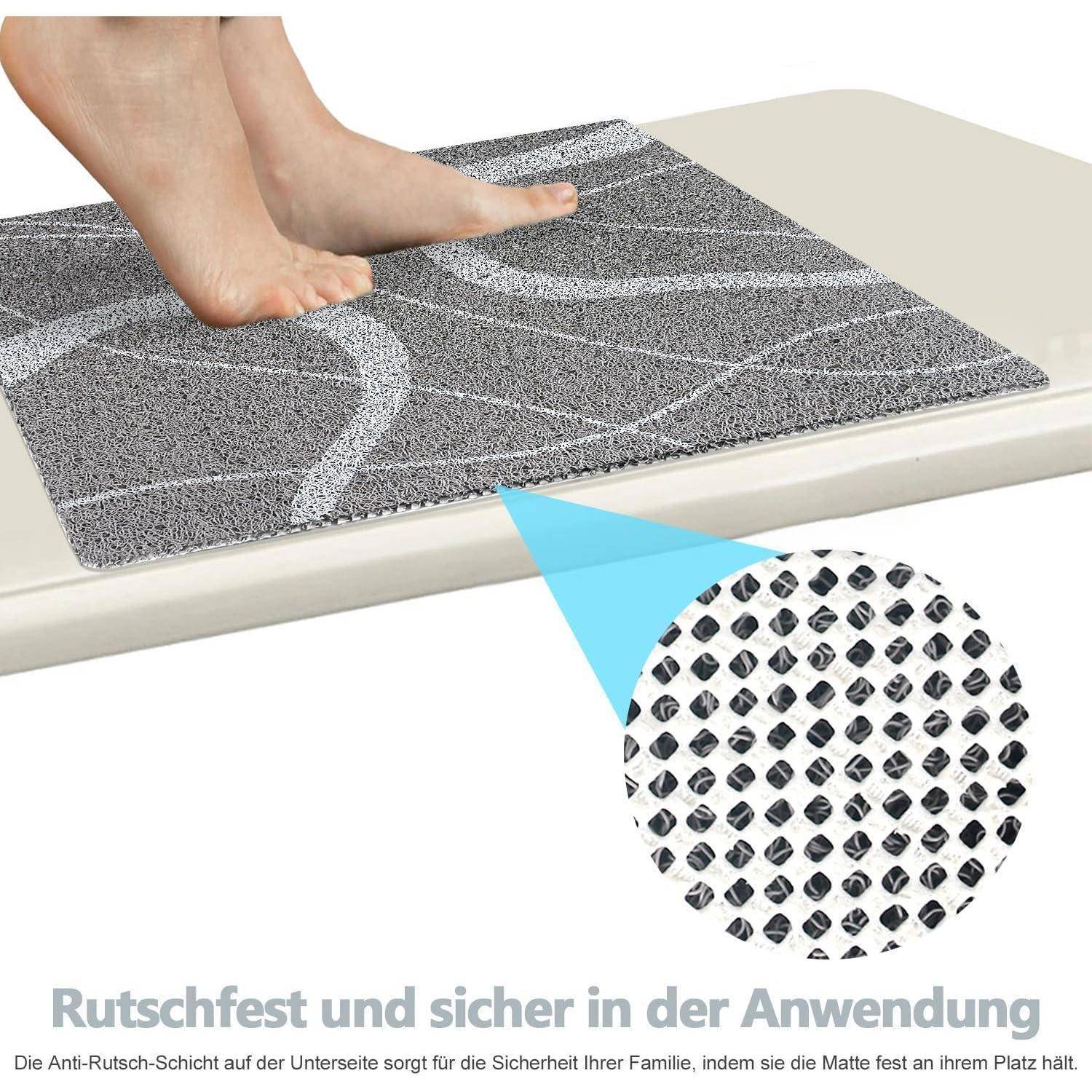 Barfüße treten auf eine graue Anti-Rutsch-Badmatte; eine eingefügte Nahaufnahme zeigt die strukturierte Griffunterseite. Deutscher Text besagt, dass sie rutschfest und sicher zu verwenden ist.
