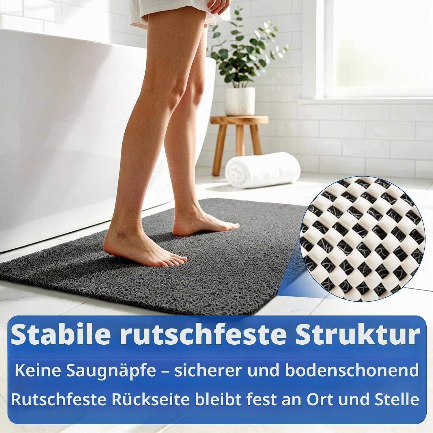 Barfüße stehen auf einer grauen Badmatte im Badezimmer; eine eingefügte Nahaufnahme hebt die rutschfeste strukturierte Unterseite hervor. Der Text lautet „Stabile rutschfeste Struktur