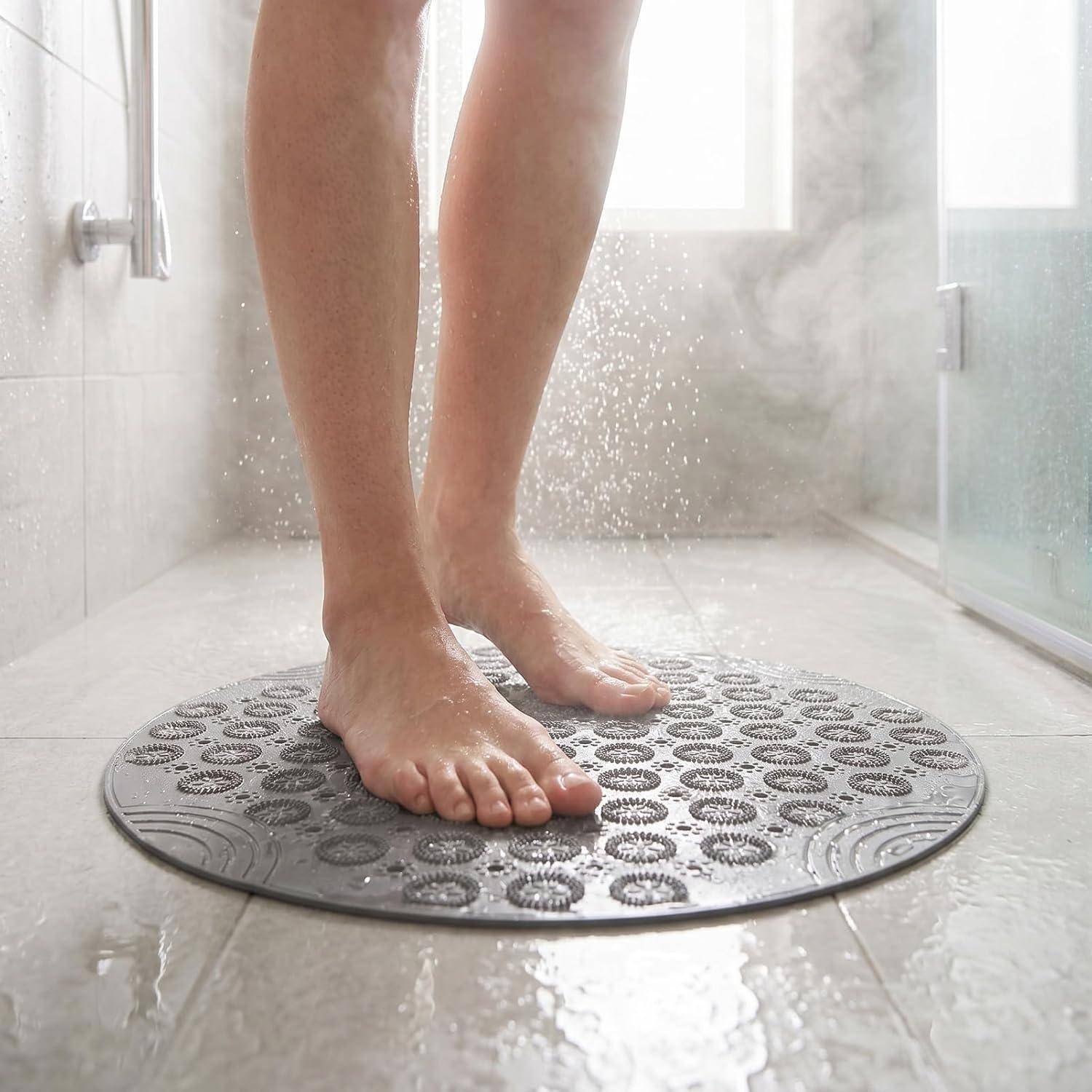 Barfüße stehen auf einer runden Badewannenmatte in einer nassen Badezimmerdusche.