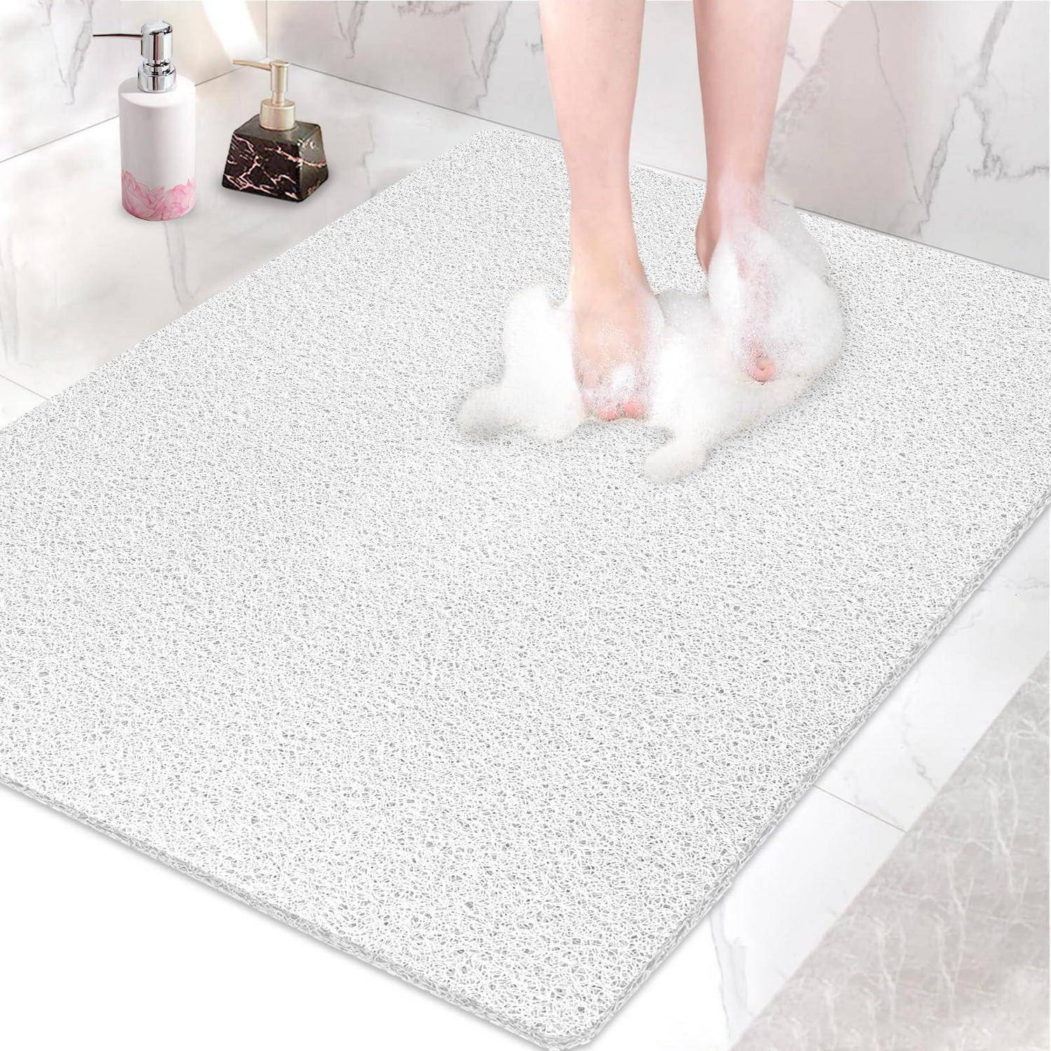 Füße stehen auf einer gesprenkelten Schaumstoff-Badezimmermatte mit Seifenblasen in einem Badezimmer, die eine weiche, saugfähige rutschfeste Bodenmatte zeigt.