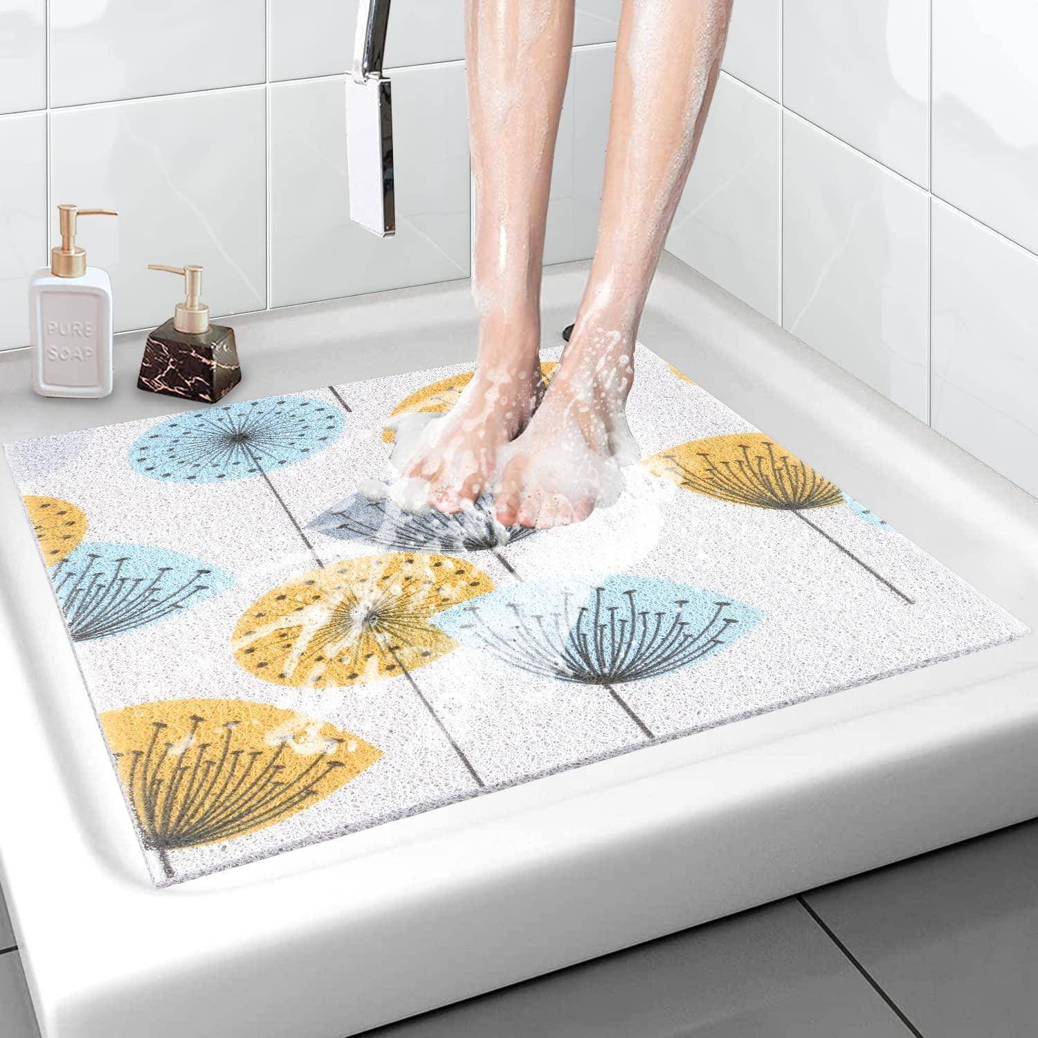 Person, die auf einer Badewannenmatte in einer Badewanne steht, zeigt eine rutschfeste, schnelltrocknende Badmatte mit buntem Blumenmuster.