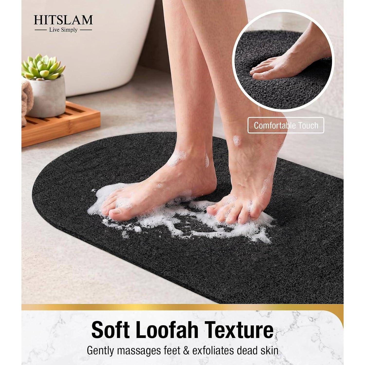 Person steht auf einer schwarzen Badematte und wird mit Schaum geschrubbt; Text sagt „Weiches Luffa-Gefühl