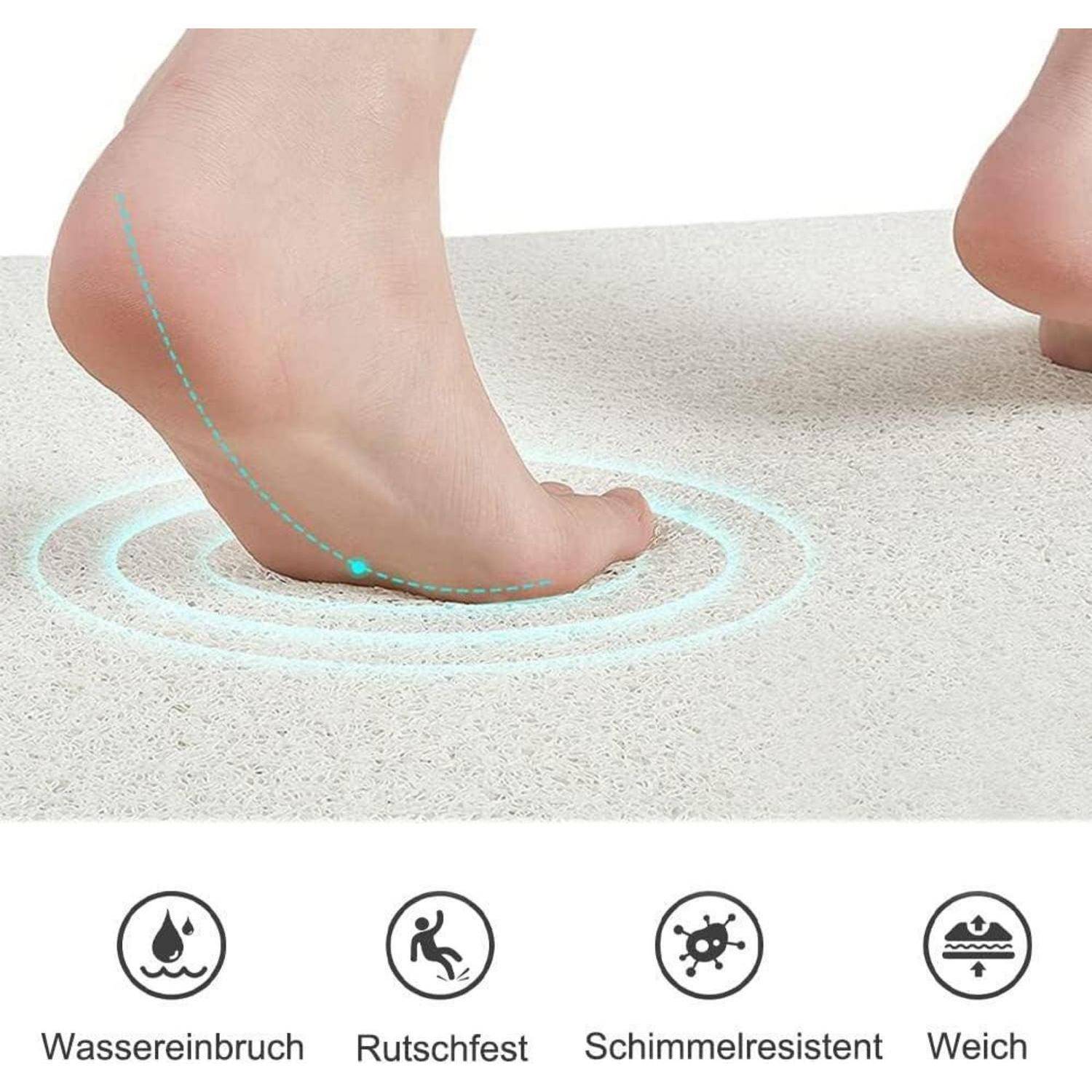 Nahaufnahme eines Fußes, der auf eine weiche Bodenfläche drückt, mit Symbolen darunter, die es auf Deutsch als wasserdicht, rutschfest, schimmelresistent und weich kennzeichnen.