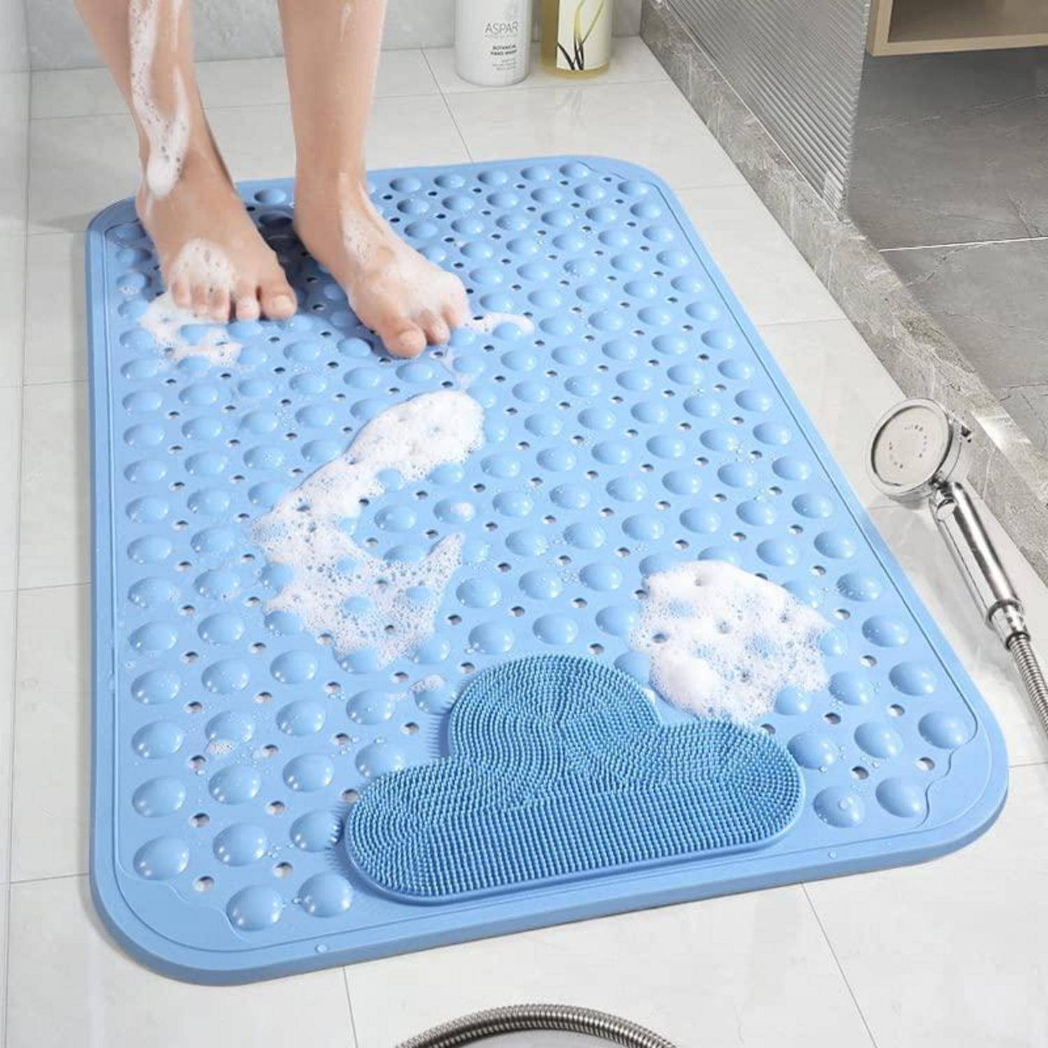 Person wäscht sich die Füße auf einer blauen strukturierten Badmatte in einer Dusche, mit Seifenschaum und einem tragbaren Duschkopf in der Nähe.