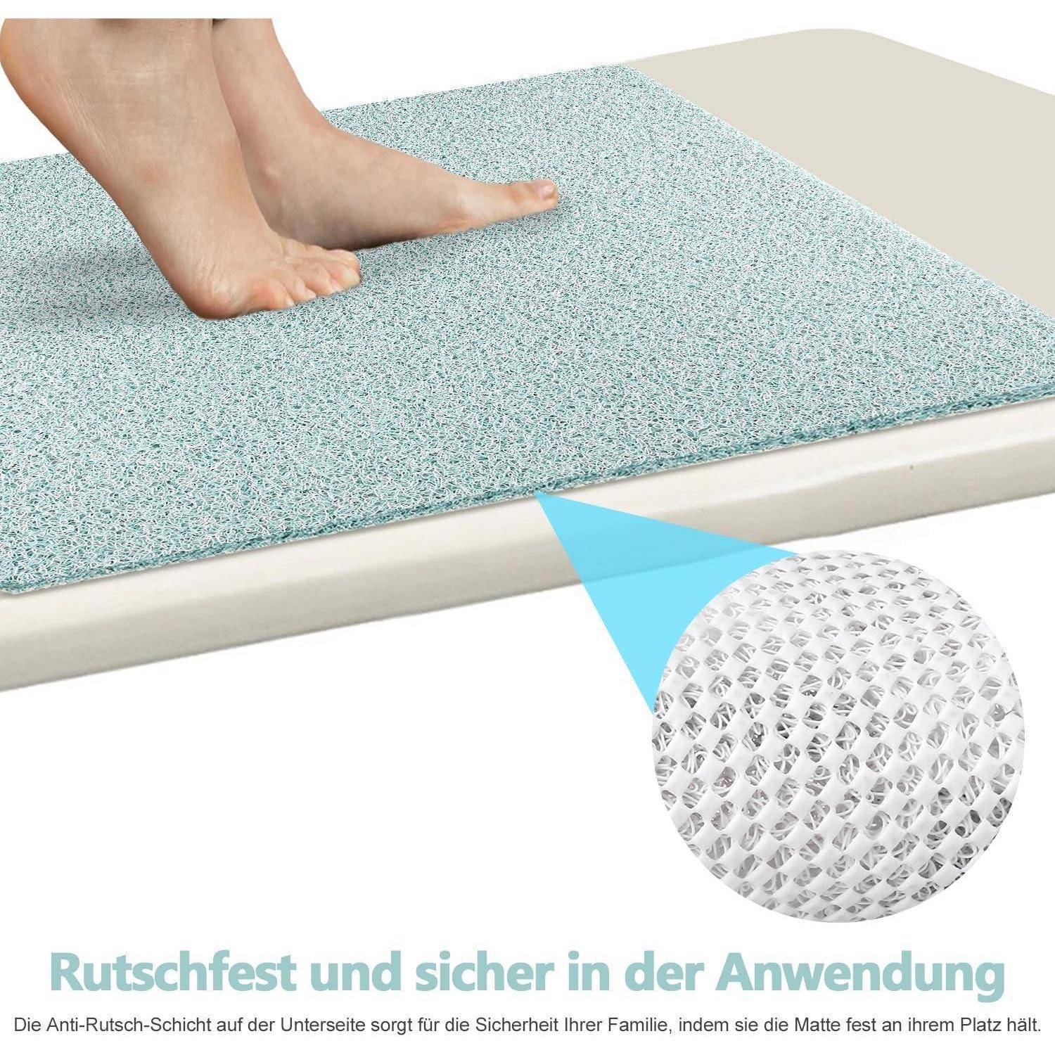 Füße stehen auf einer rutschfesten Matte; Eine vergrößerte Nahaufnahme zeigt die strukturierte Unterseite mit deutschem Text, der besagt, dass sie sicher und zuverlässig im Gebrauch ist.